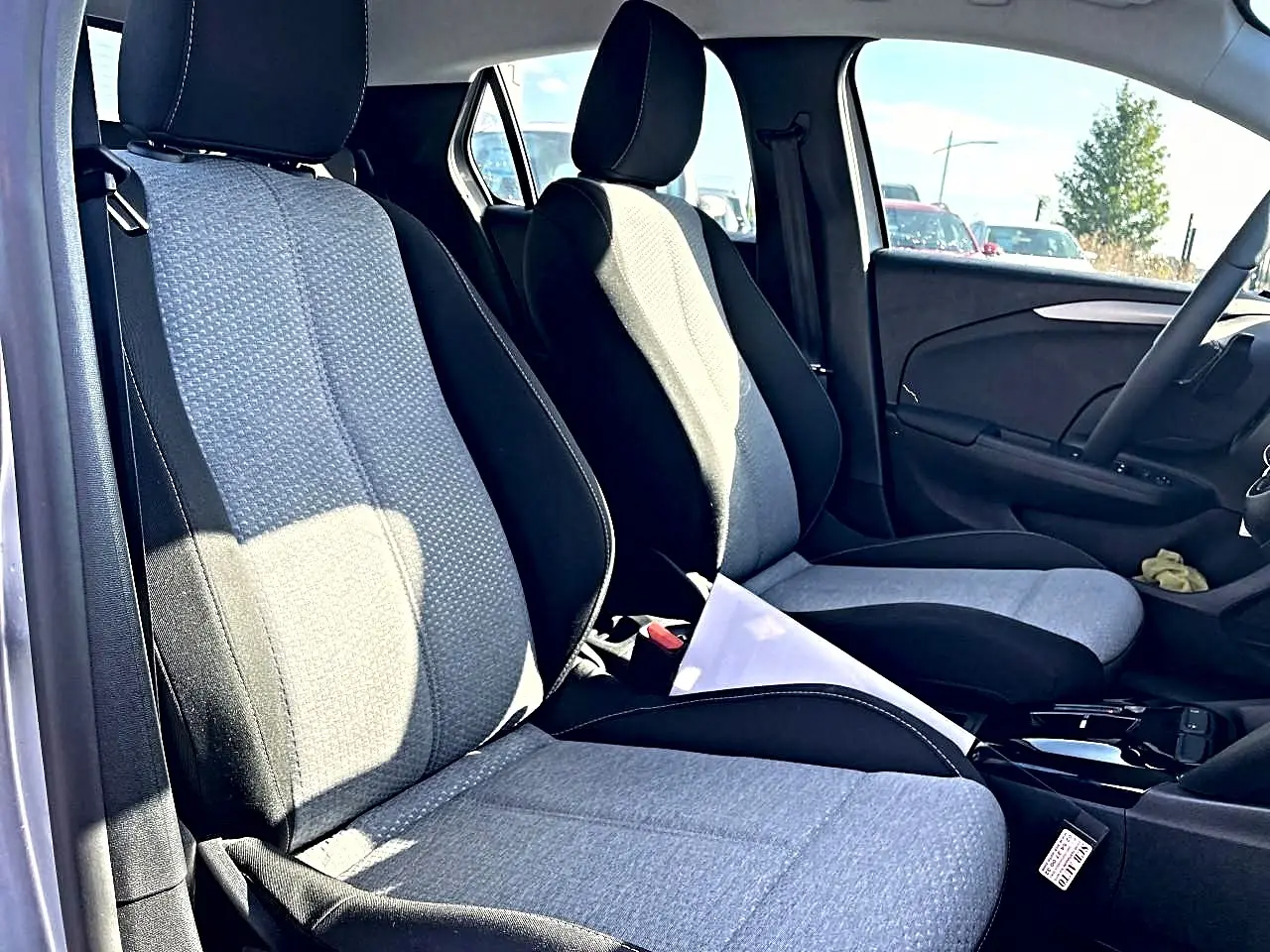 Vue intérieure côté conducteur de l’Opel Corsa 2025, sièges tissu noir et gris, volant multifonction sport visible.