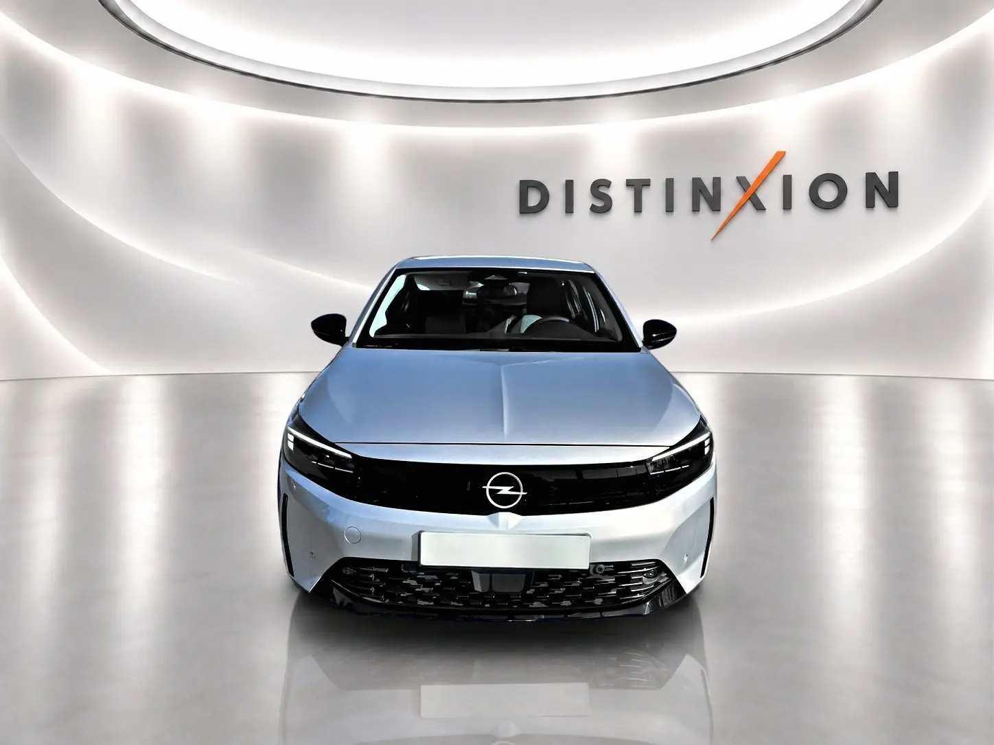 Vue frontale d'une Opel Corsa gris alu 2025 avec calandre noire et logo Opel lumineux sur fond blanc.