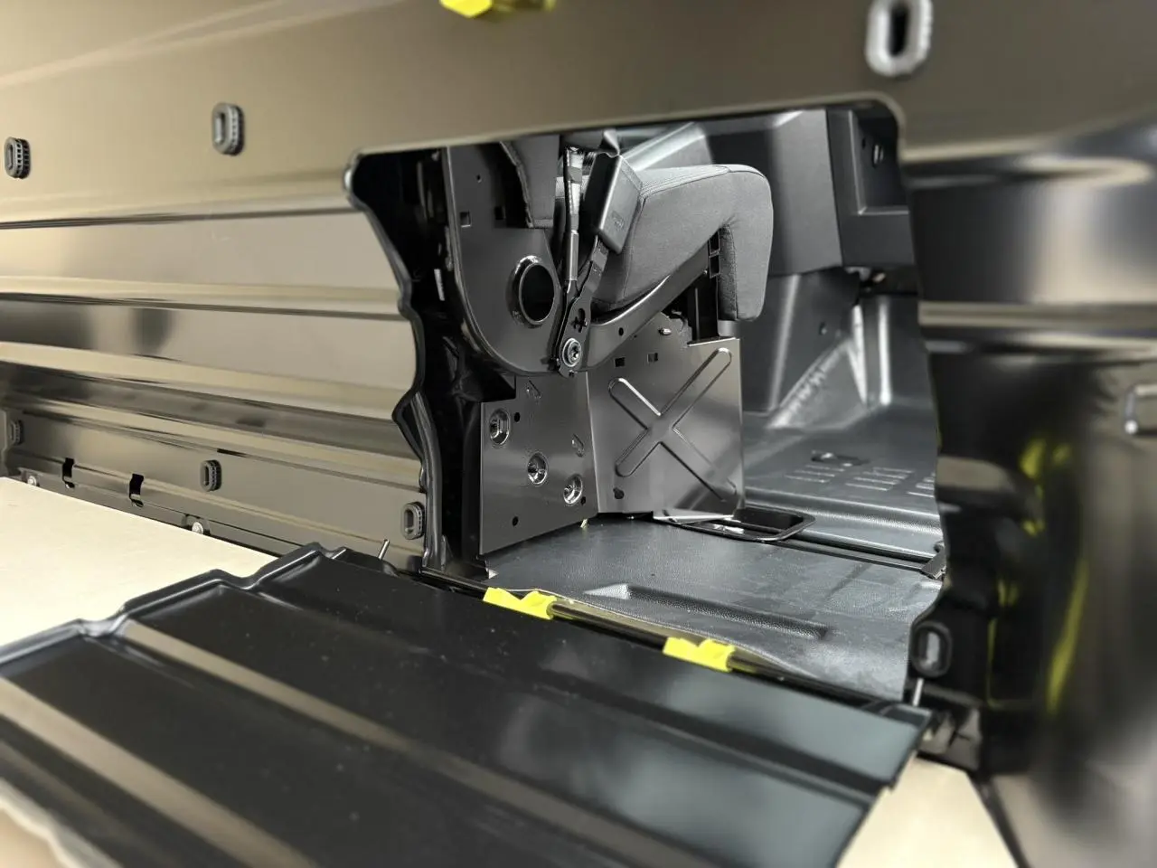 Détail intérieur côté droit du Peugeot Expert Fourgon blanc, montrant la trappe de charge longue et la banquette relevable.