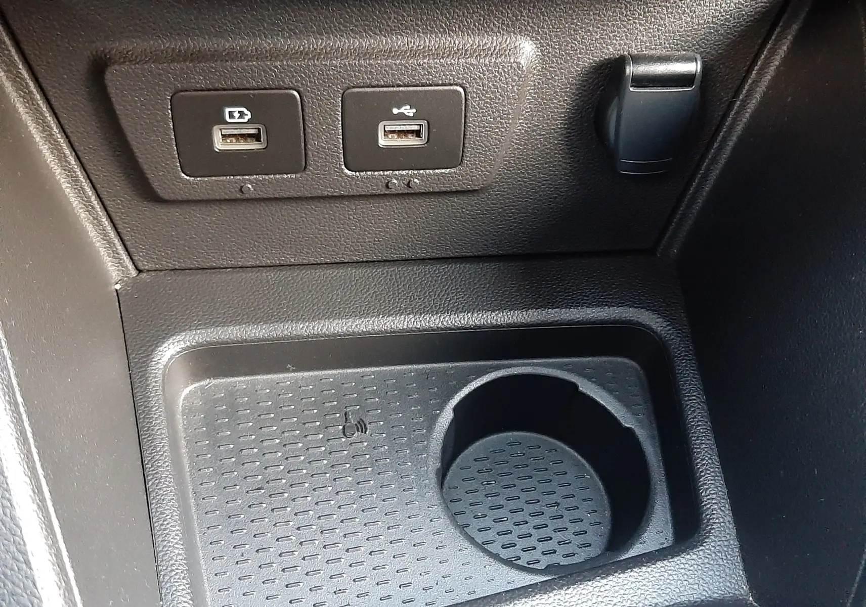 Vue rapprochée de la console centrale du Dacia Duster 2023, montrant deux ports USB et un emplacement porte-gobelet noir.