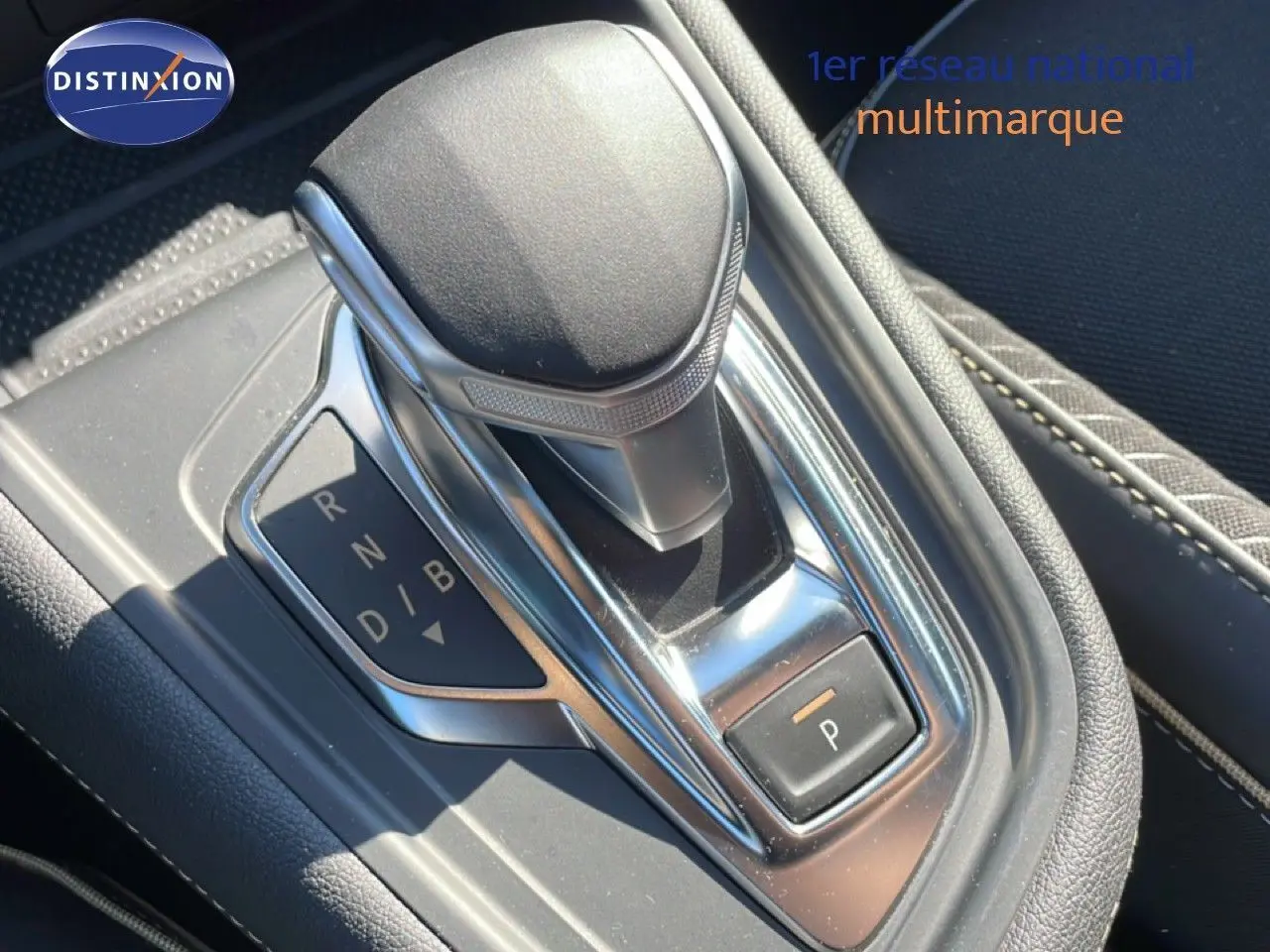 Gros plan sur le levier de vitesses automatique de la Renault Symbioz noir étoile métal, avec indication des modes de conduite.