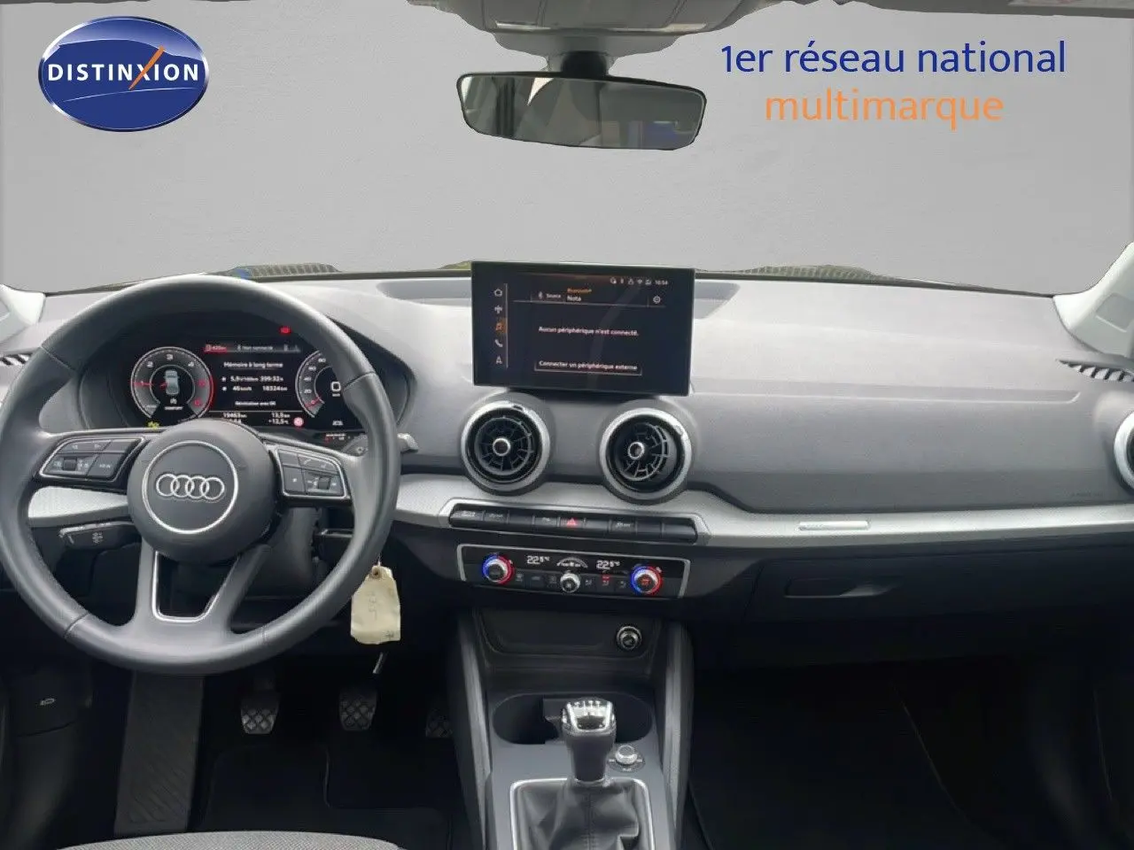 Vue intérieure avant de l'Audi Q2 30 TDI S-Line 2025, tableau de bord noir avec écran central et volant cuir multifonction.