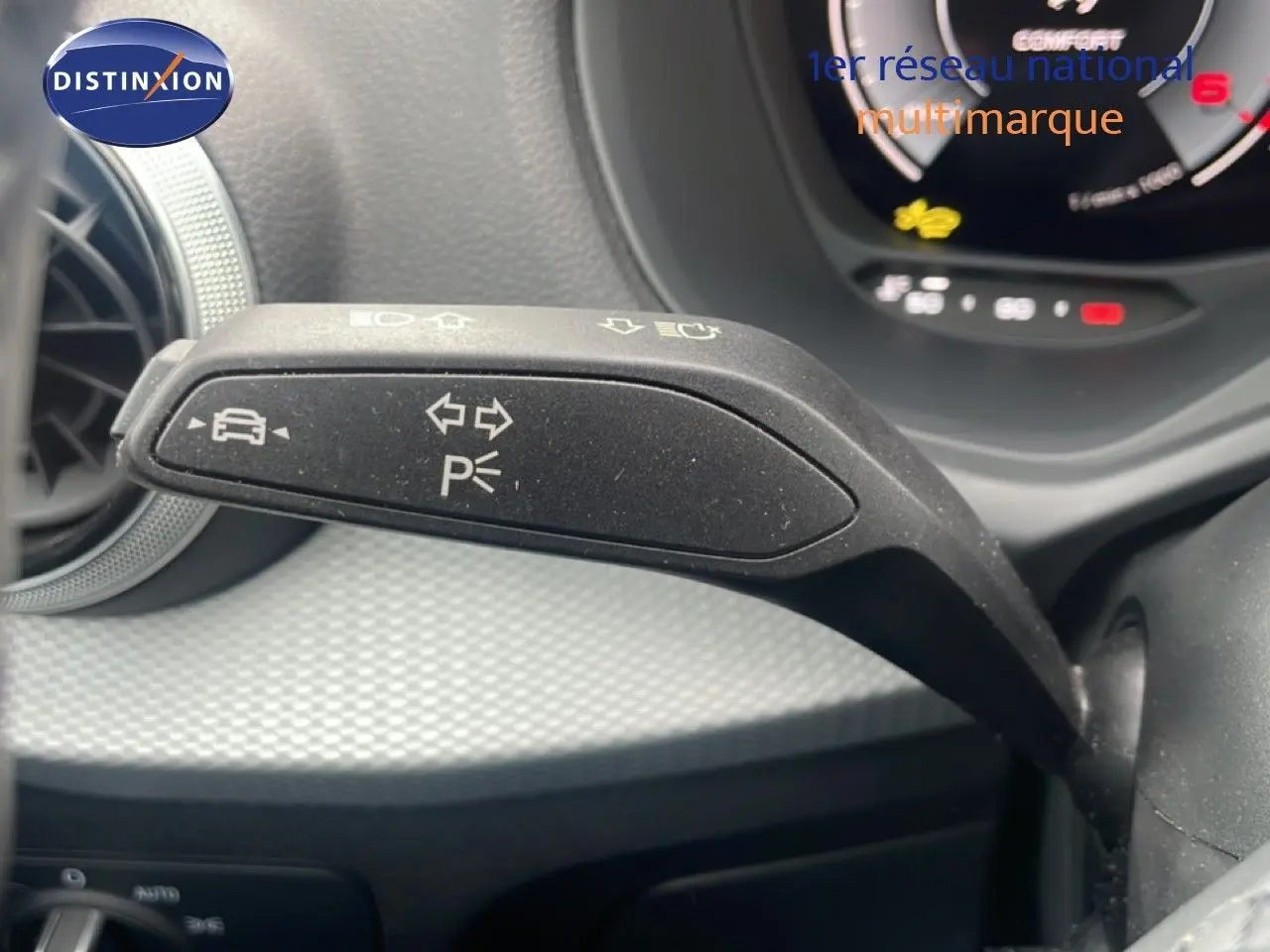 Gros plan sur la commande de clignotant à gauche dans l’habitacle d’un Audi Q2 noir mito metal 2025.