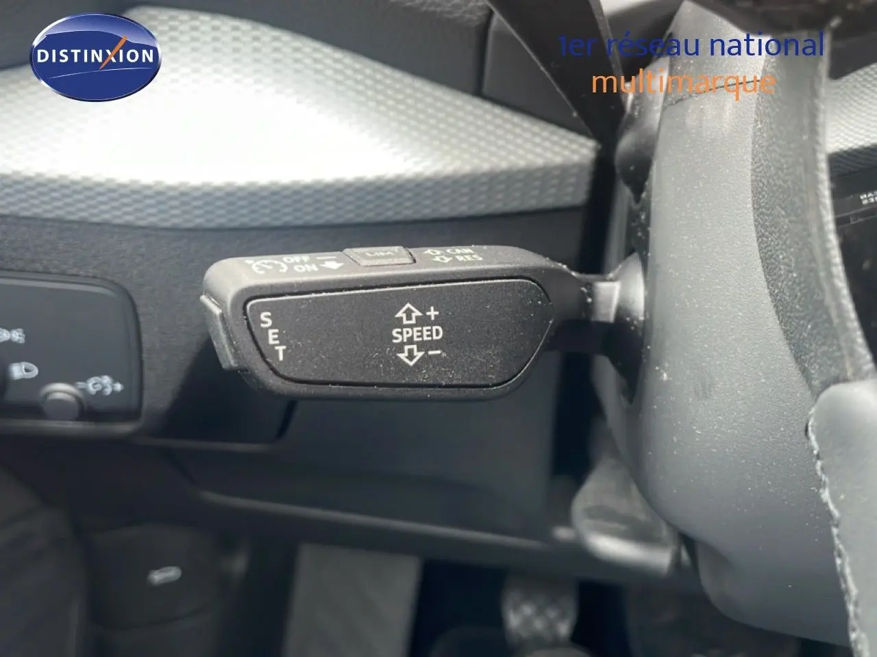 Gros plan sur la commande de régulateur de vitesse à gauche du volant d’un Audi Q2 noir Mito Metal 2025.