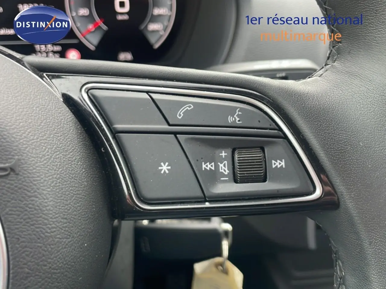 Gros plan sur les commandes audio et téléphone au volant cuir noir de l'Audi Q2 30 TDI S-Line 2025.