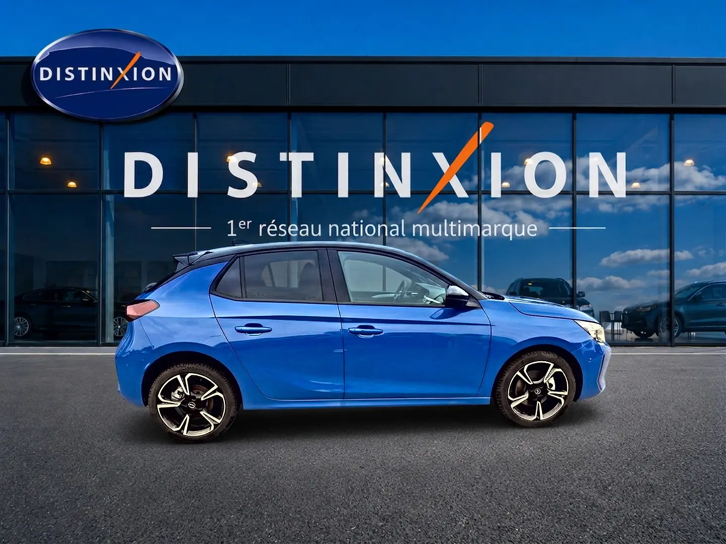 Opel Corsa 1.2 turbo 100 GS bleu vue de profil côté gauche devant une vitrine Distinxion.