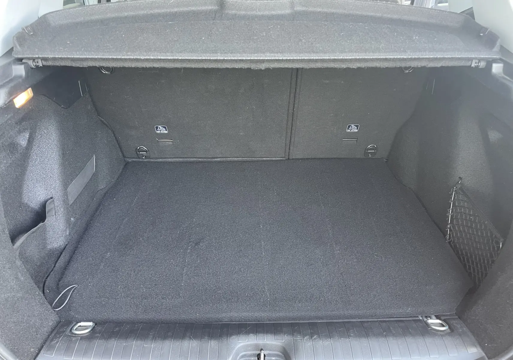 Coffre ouvert du Peugeot 2008 gris 2019, vue intérieure montrant un espace de chargement propre et bien agencé.