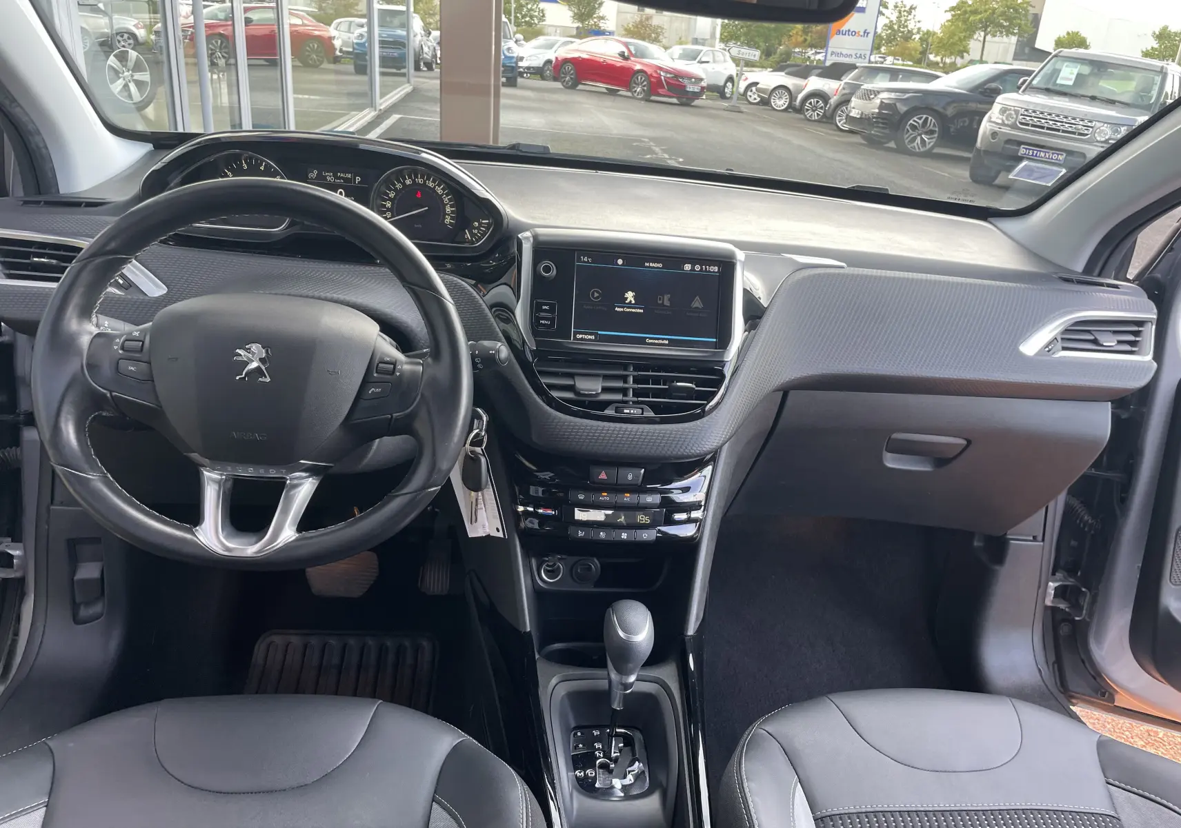 Vue intérieure avant du Peugeot 2008 gris 2019, tableau de bord moderne avec écran tactile et volant cuir multifonction.