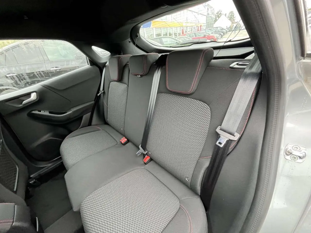 Vue intérieure arrière côté droit des sièges arrière en tissu gris avec surpiqûres rouges du Ford Puma 2023 finition ST Line.