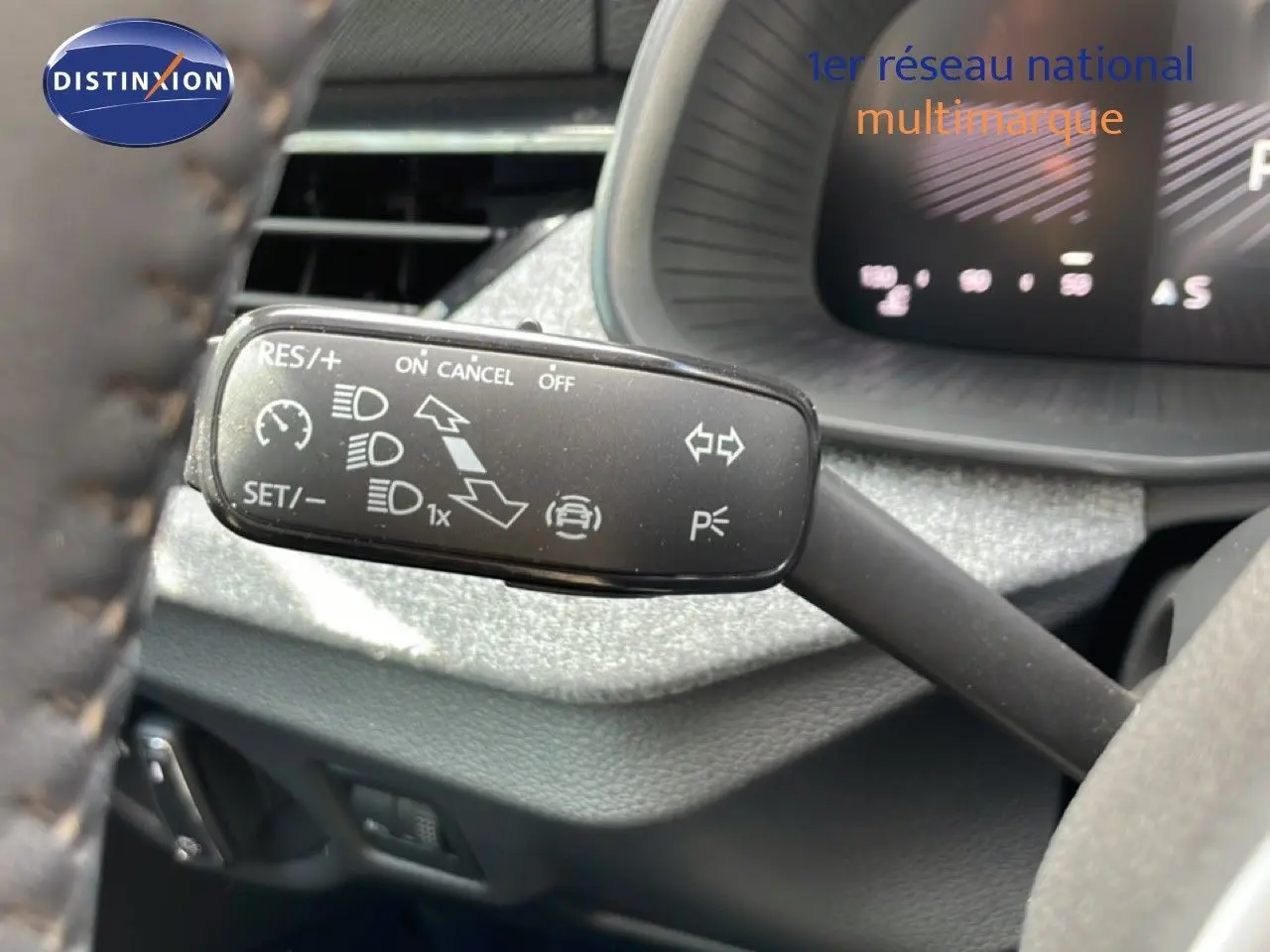 Gros plan sur la commande de régulateur de vitesse à gauche du volant dans l'habitacle d'une Skoda Scala 2025.