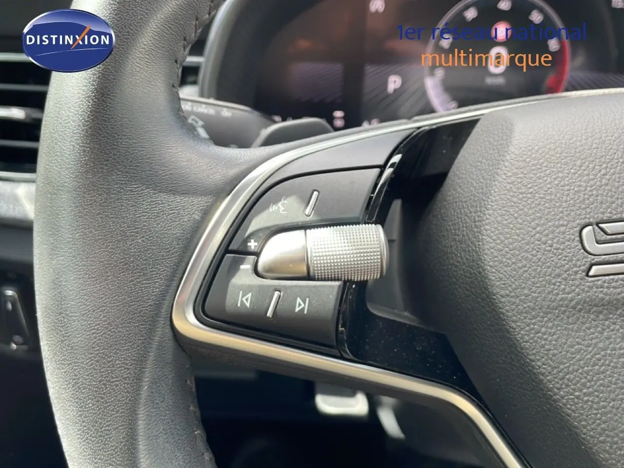 Gros plan sur le volant multifonction gris noir de la Skoda Scala 2025, avec commandes audio et régulateur.