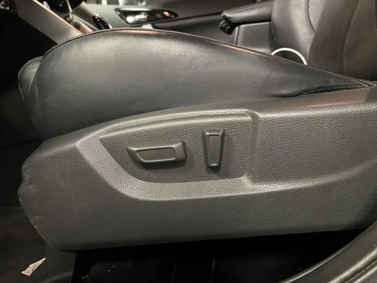 Gros plan sur les commandes de réglage électrique du siège conducteur en cuir noir du Mitsubishi Eclipse Cross gris 2022.