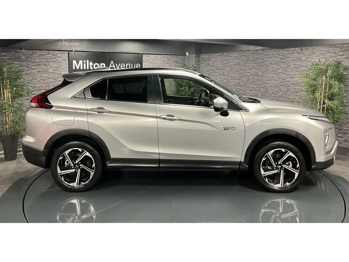 Profil côté gauche du Mitsubishi Eclipse Cross gris métallisé 2022 avec jantes alliage bi-ton et vitres surteintées.