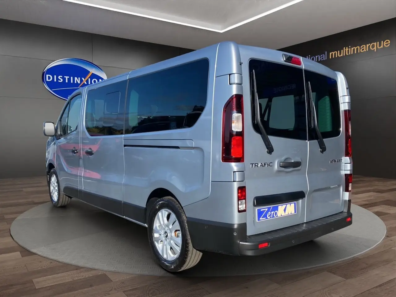 Renault Trafic Combi gris Highland vu en 3/4 arrière droit, portes arrière vitrées et jantes alliage 17 pouces.