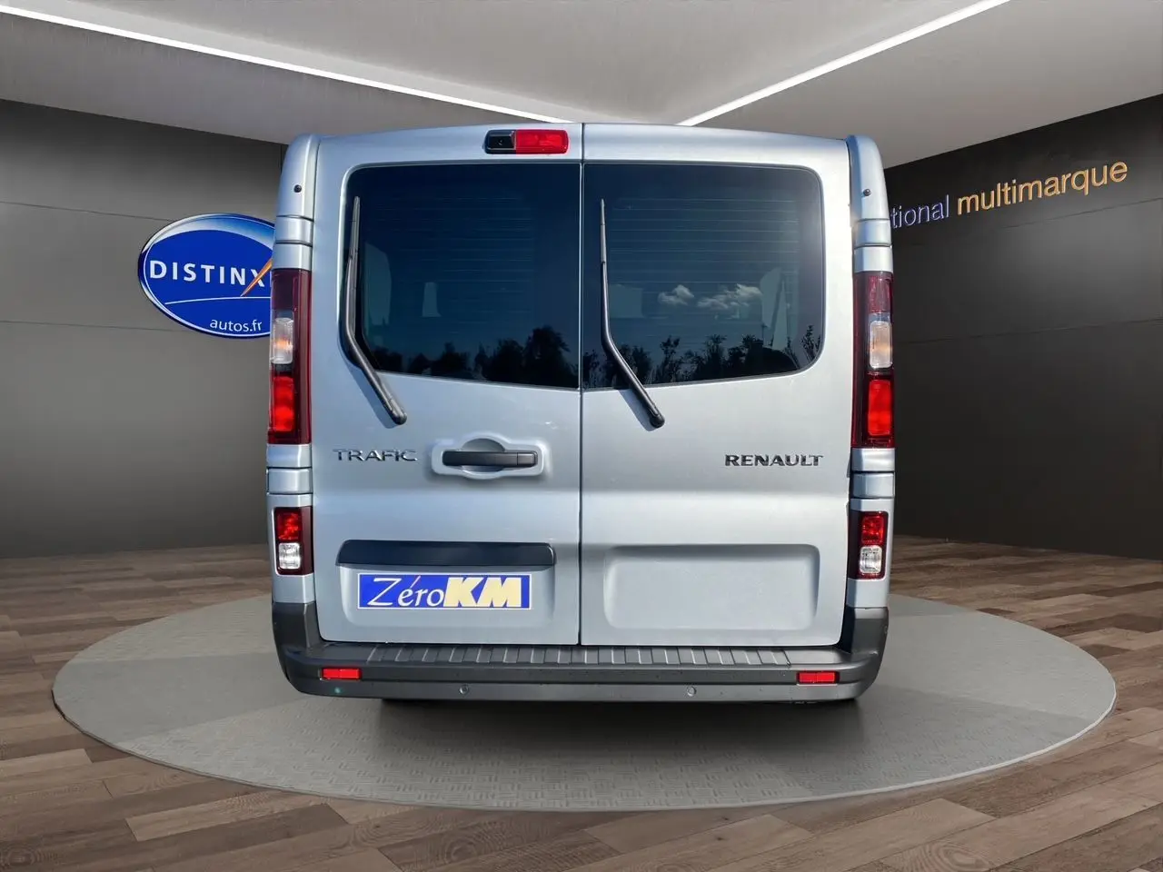 Vue arrière du Renault Trafic Combi gris Highland avec portes vitrées et essuie-glaces sur vitres arrière.