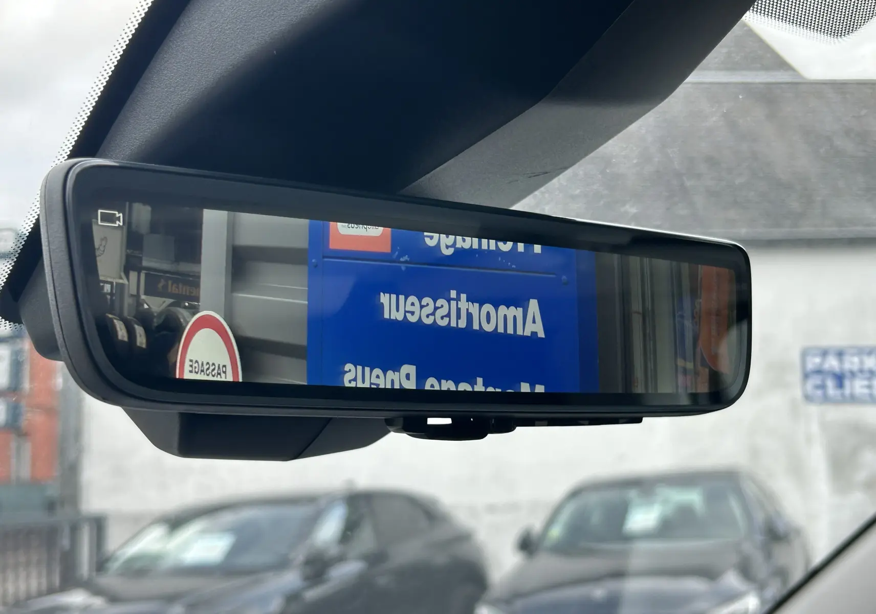 Rétroviseur intérieur numérique du Citroën Berlingo Fourgon blanc, affichant une vue arrière floue du parking.