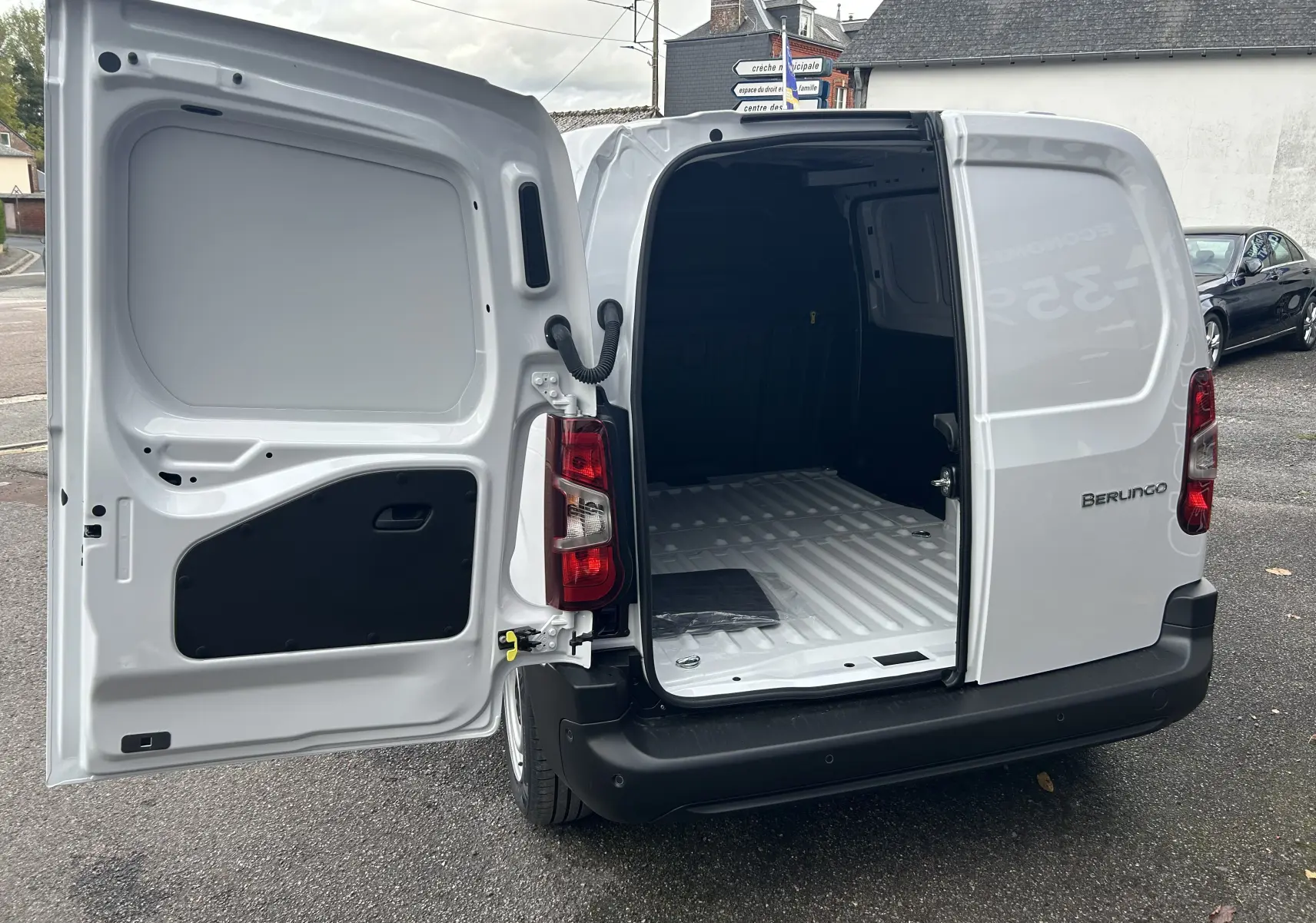 Vue arrière ouverte du Citroën Berlingo Fourgon blanc 2025 montrant l'espace de chargement vide et les portes battantes.