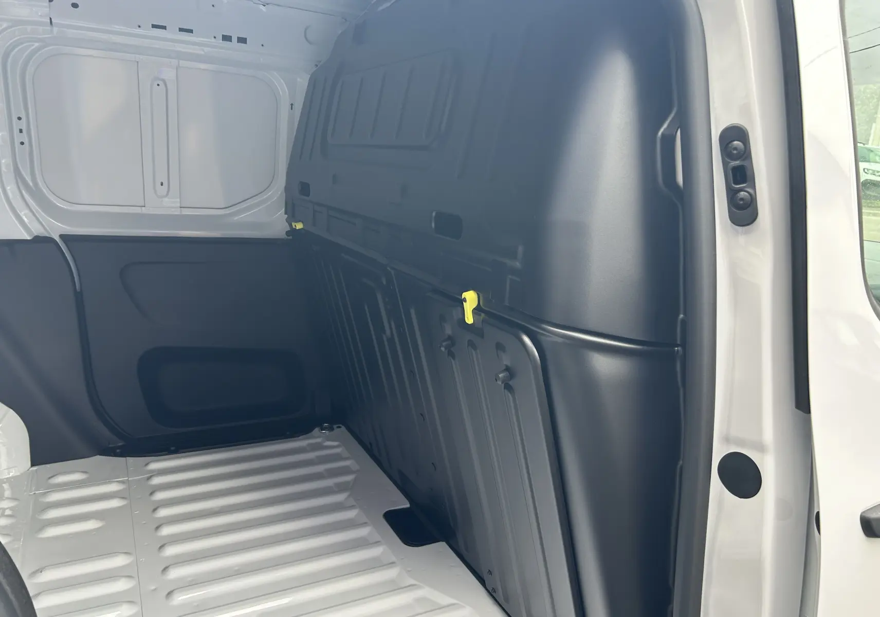 Intérieur du fourgon Citroën Berlingo BlueHDi blanc, vue du compartiment de chargement côté droit avec cloison noire.