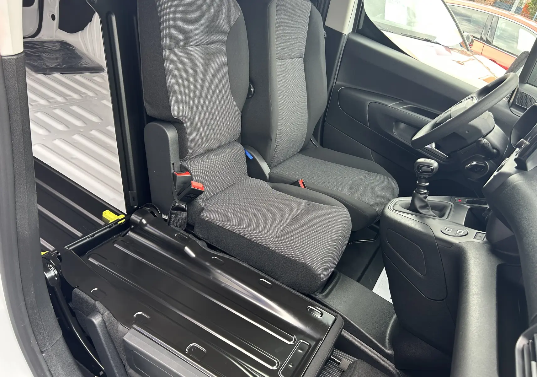 Vue intérieure côté droit du Citroën Berlingo Fourgon blanc 2025, montrant sièges avant en tissu et levier de vitesses manuel.
