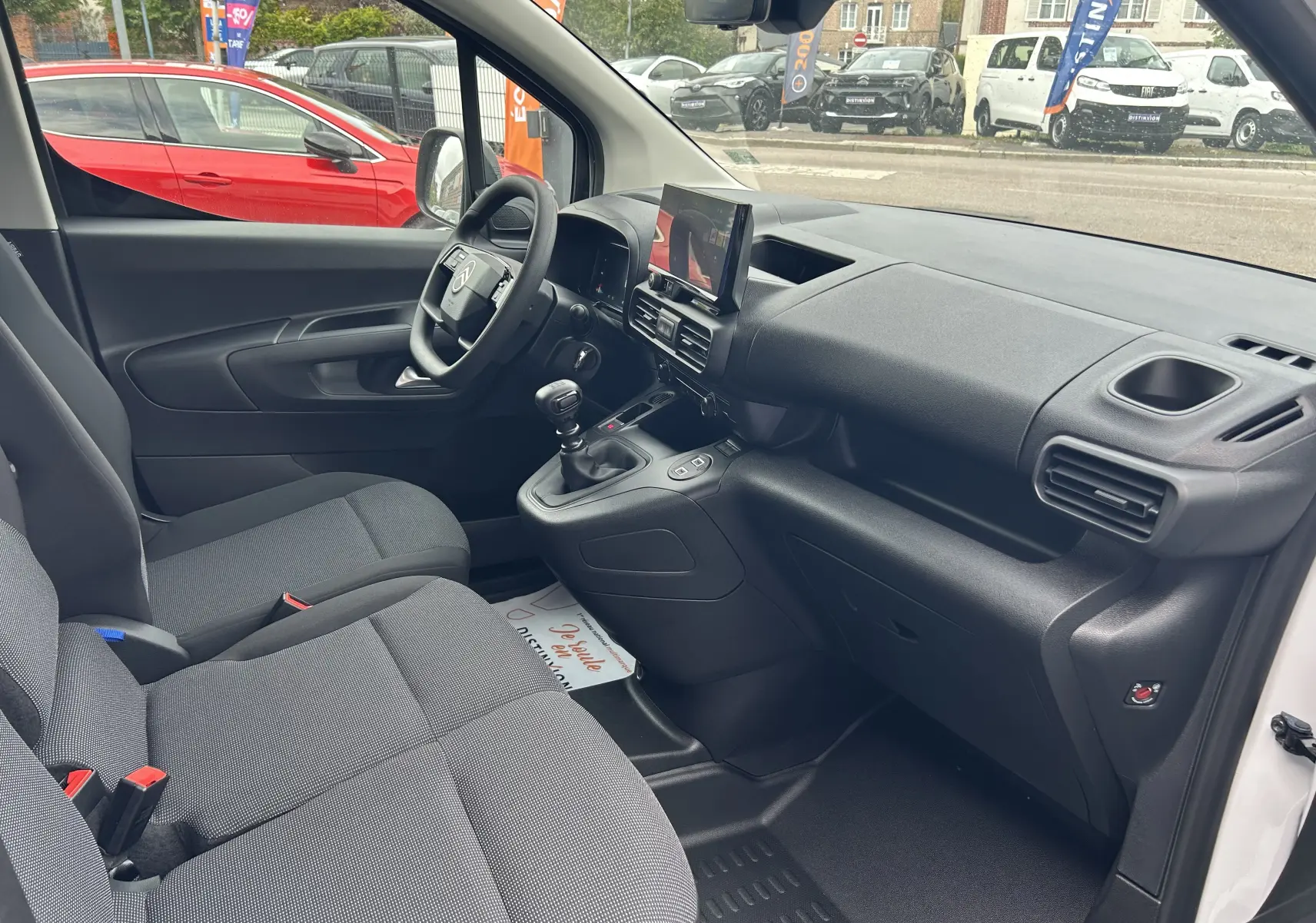 Intérieur avant du Citroën Berlingo Fourgon blanc 2025, vue côté conducteur avec tableau de bord et écran tactile central.