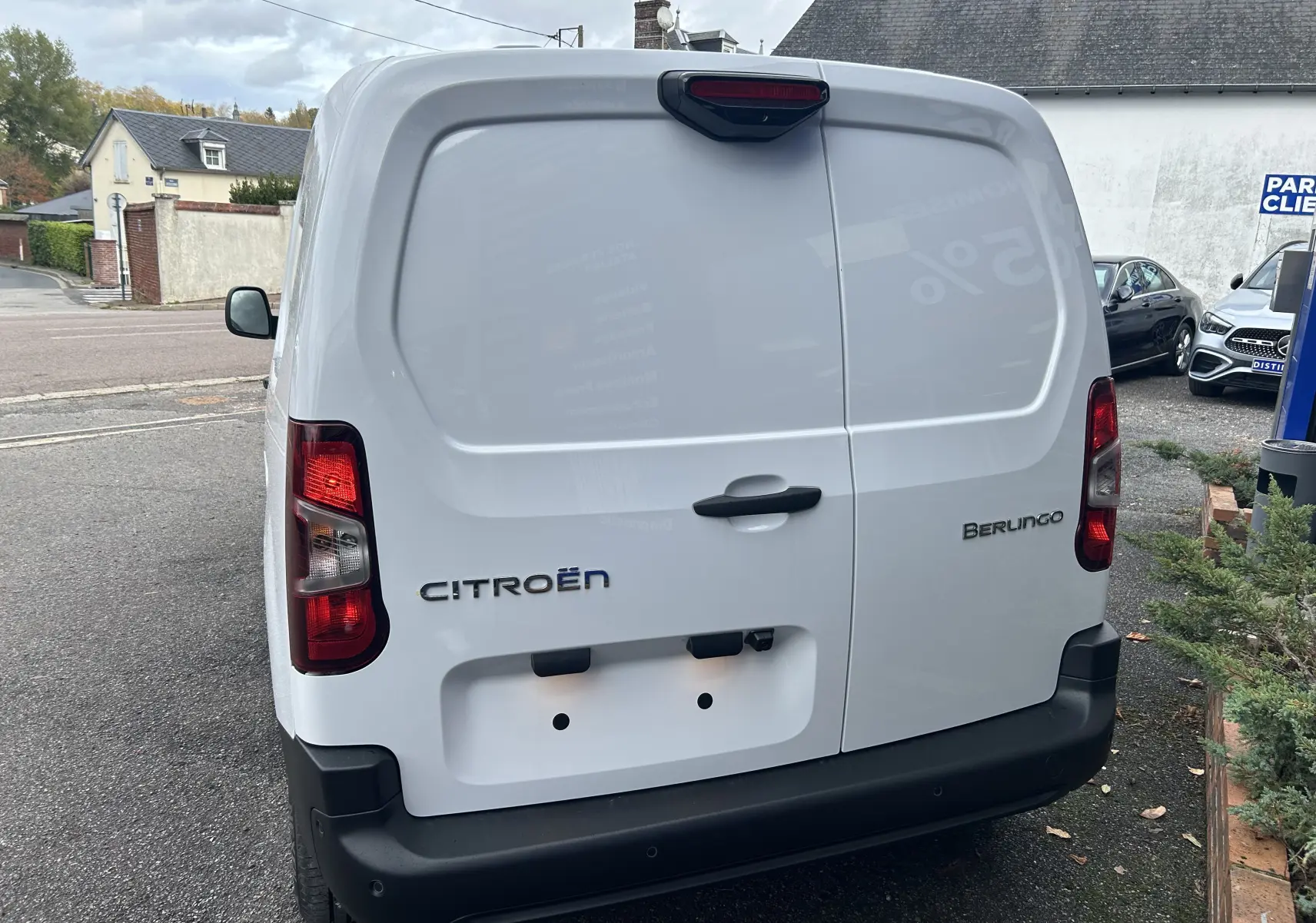 Vue arrière d'un Citroën Berlingo Fourgon blanc avec portes battantes et feux arrière rouges.