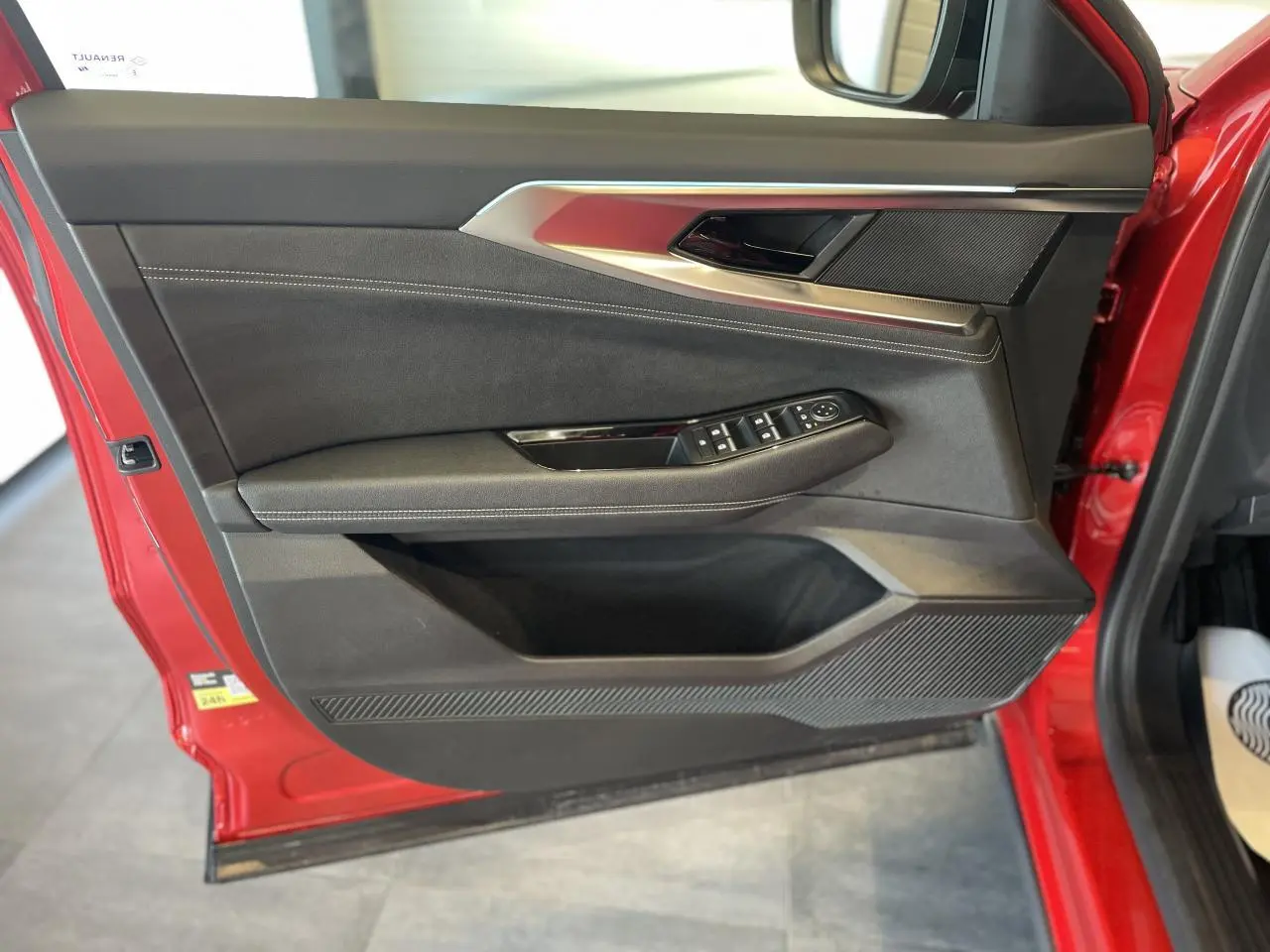 Vue de la porte avant gauche rouge du Renault Rafale 2025 avec garniture textile refined et commandes électriques.