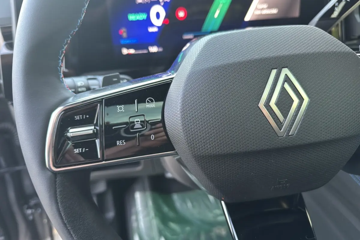Gros plan sur le volant multifonctions noir avec logo Renault et commandes intégrées du Renault Austral New 200 Esprit Alpine.