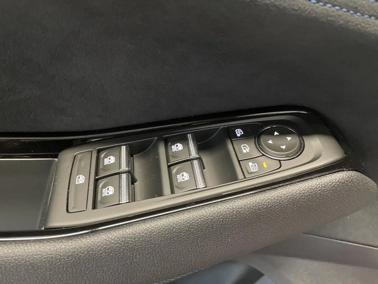 Gros plan sur les commandes de lève-vitres et rétroviseurs sur la porte côté conducteur du Renault Austral Esprit Alpine.