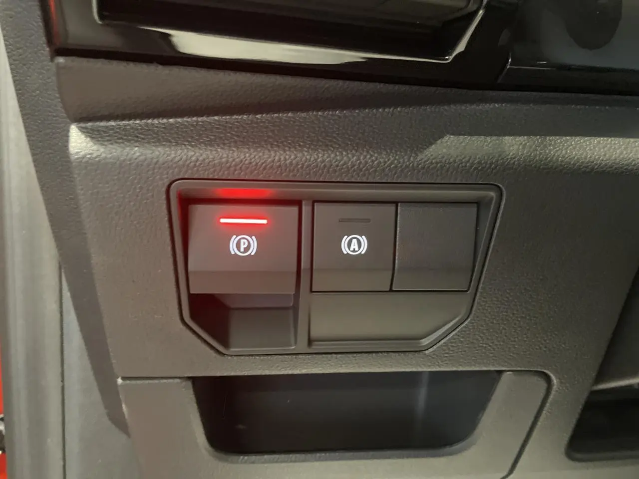 Gros plan sur les commandes de frein de parking et auto-hold du Renault Austral 2025, intérieur noir.