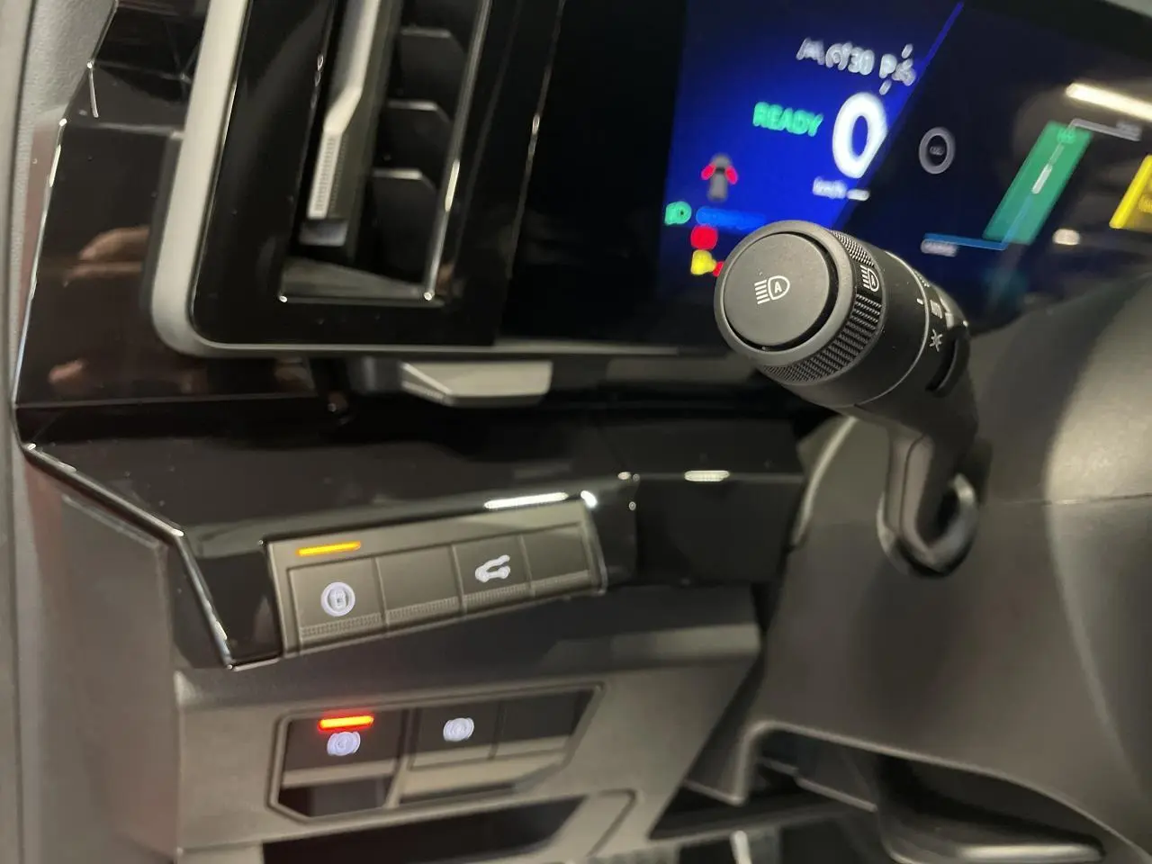 Détail intérieur du tableau de bord noir brillant du Renault Austral 2025 avec commandes éclairées et écran numérique.