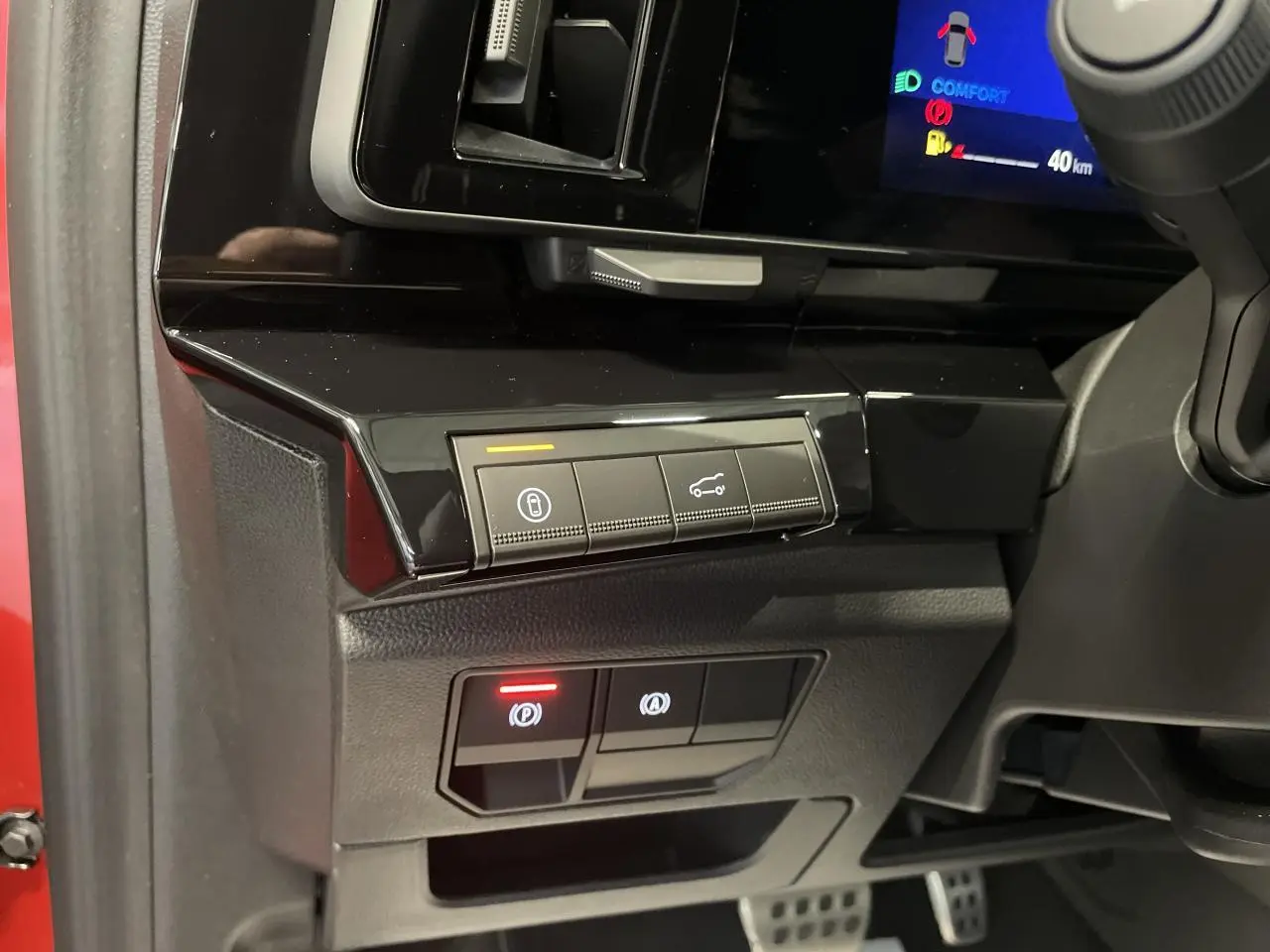 Vue intérieure côté conducteur du tableau de bord noir brillant et commandes électroniques du Renault Austral 2025 rouge métallisé.