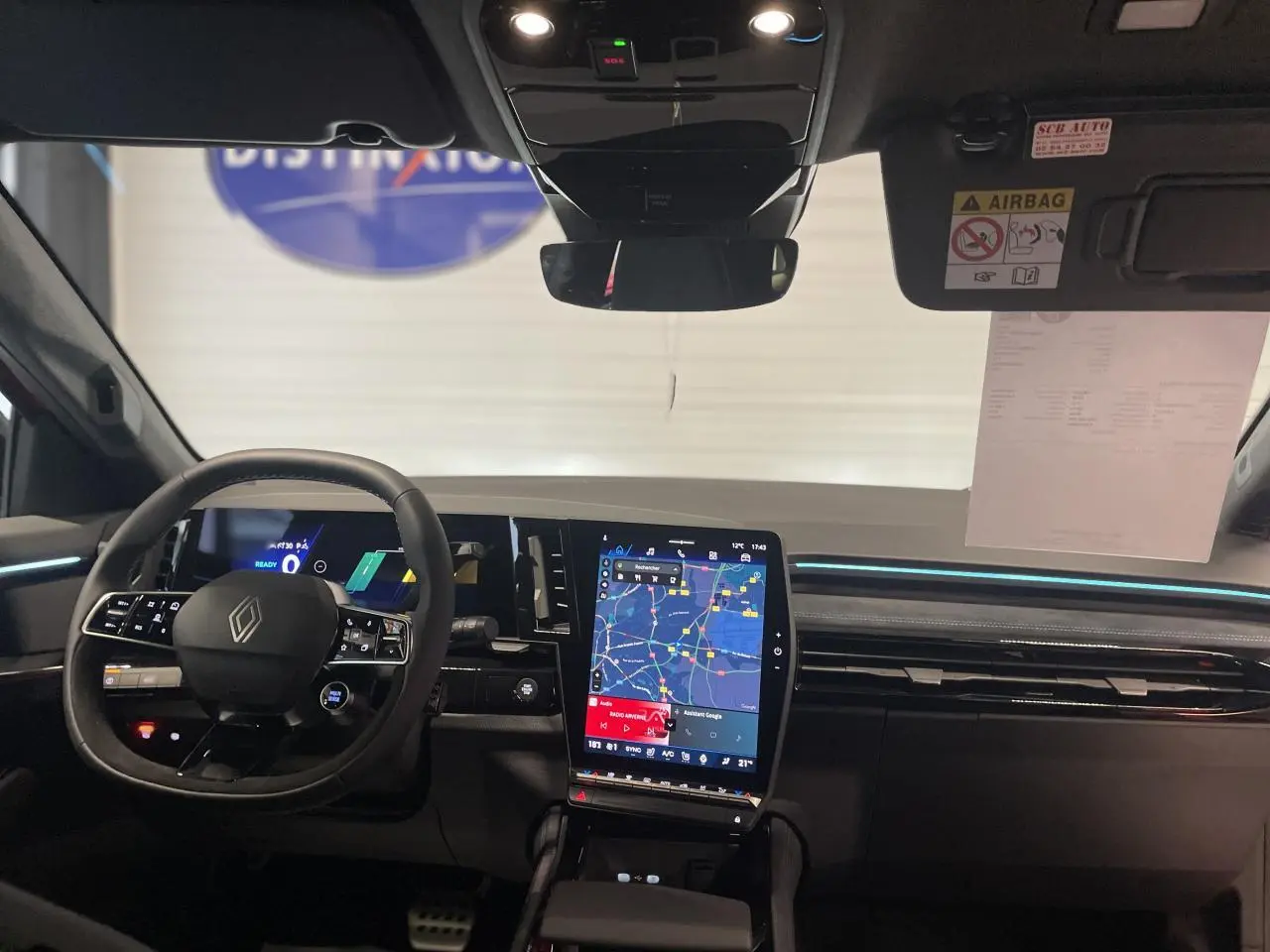 Vue intérieure avant du Renault Austral 2025 avec tableau de bord numérique et écran tactile central vertical.