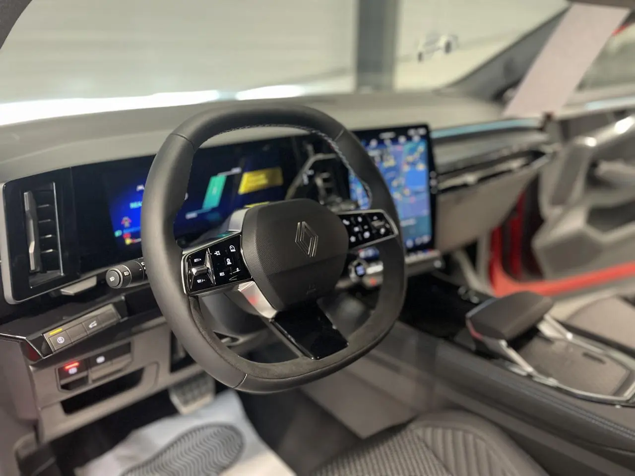 Vue intérieure du volant et tableau de bord numérique du Renault Austral 2025 avec finitions noires et écrans tactiles lumineux.