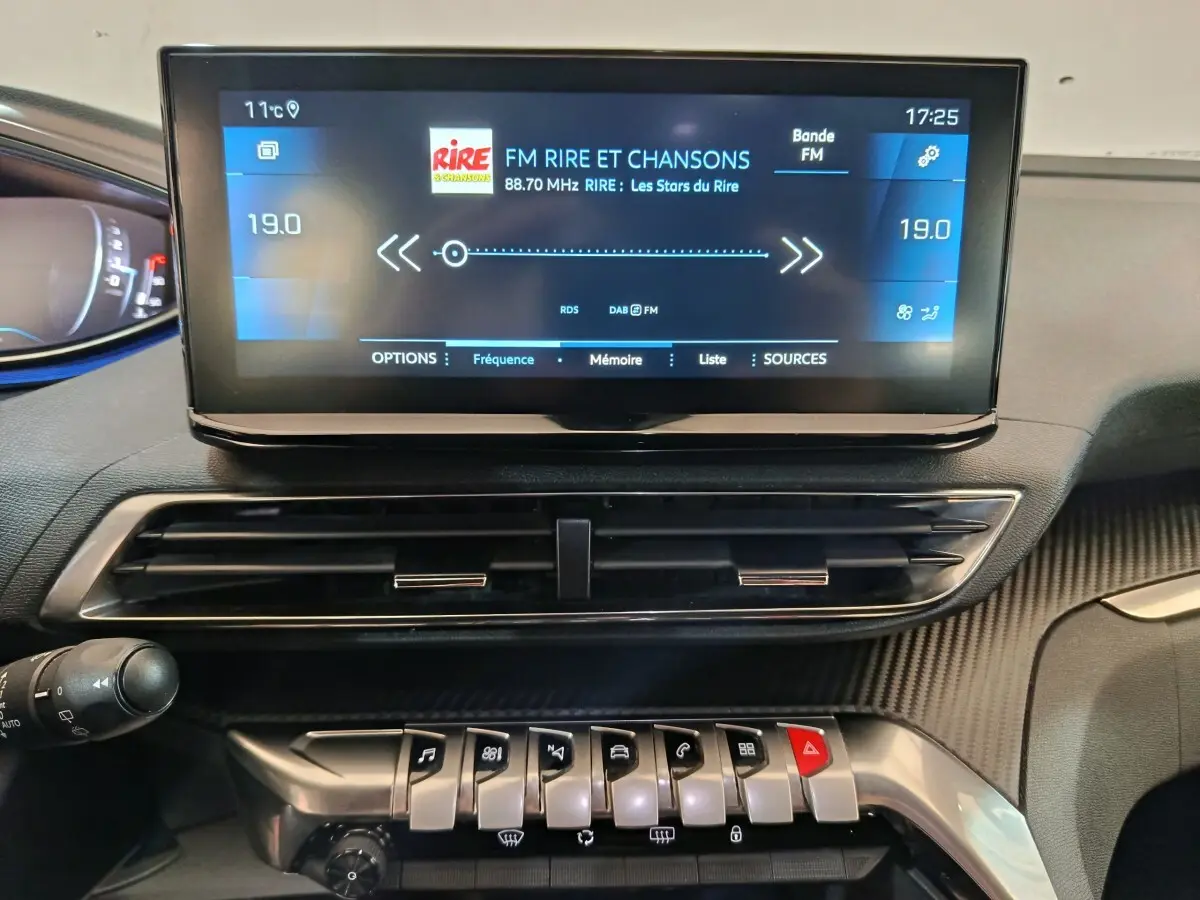 Vue rapprochée du tableau de bord du Peugeot 5008 gris clair 2023, avec écran tactile central et commandes piano.