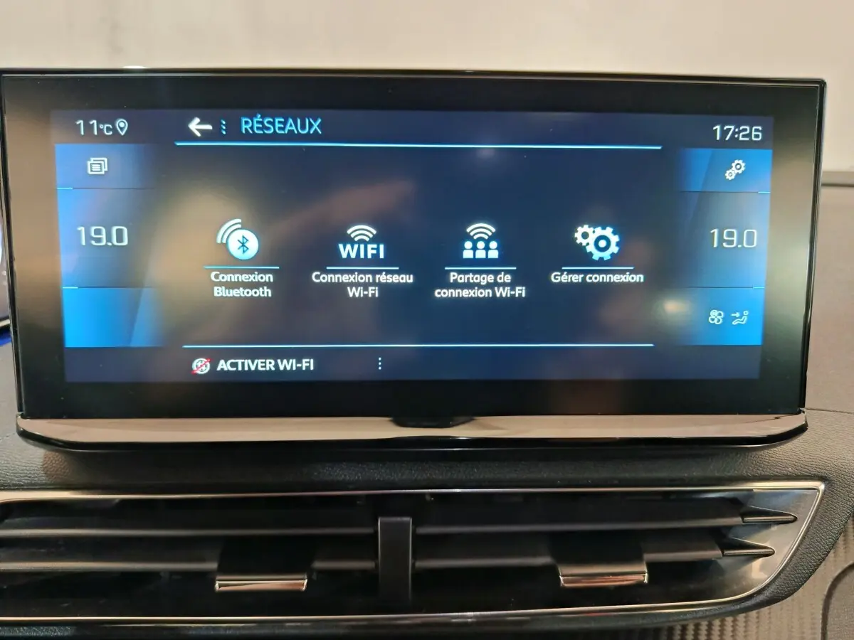 Écran tactile central du tableau de bord du Peugeot 5008 gris clair affichant les options de connexion Wi-Fi et Bluetooth.