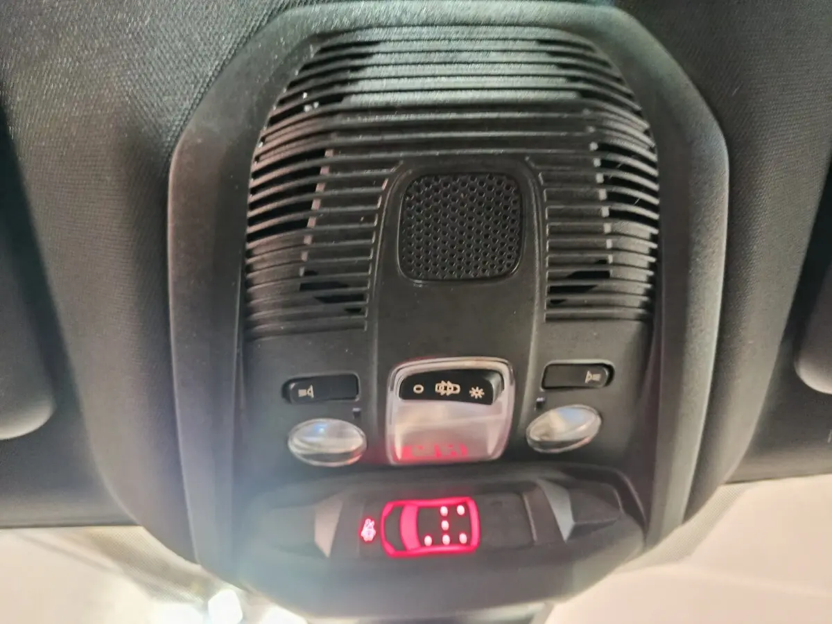 Vue en gros plan du plafonnier intérieur noir avec commandes d’éclairage et alerte de ceinture du Peugeot 5008 gris clair 2023.