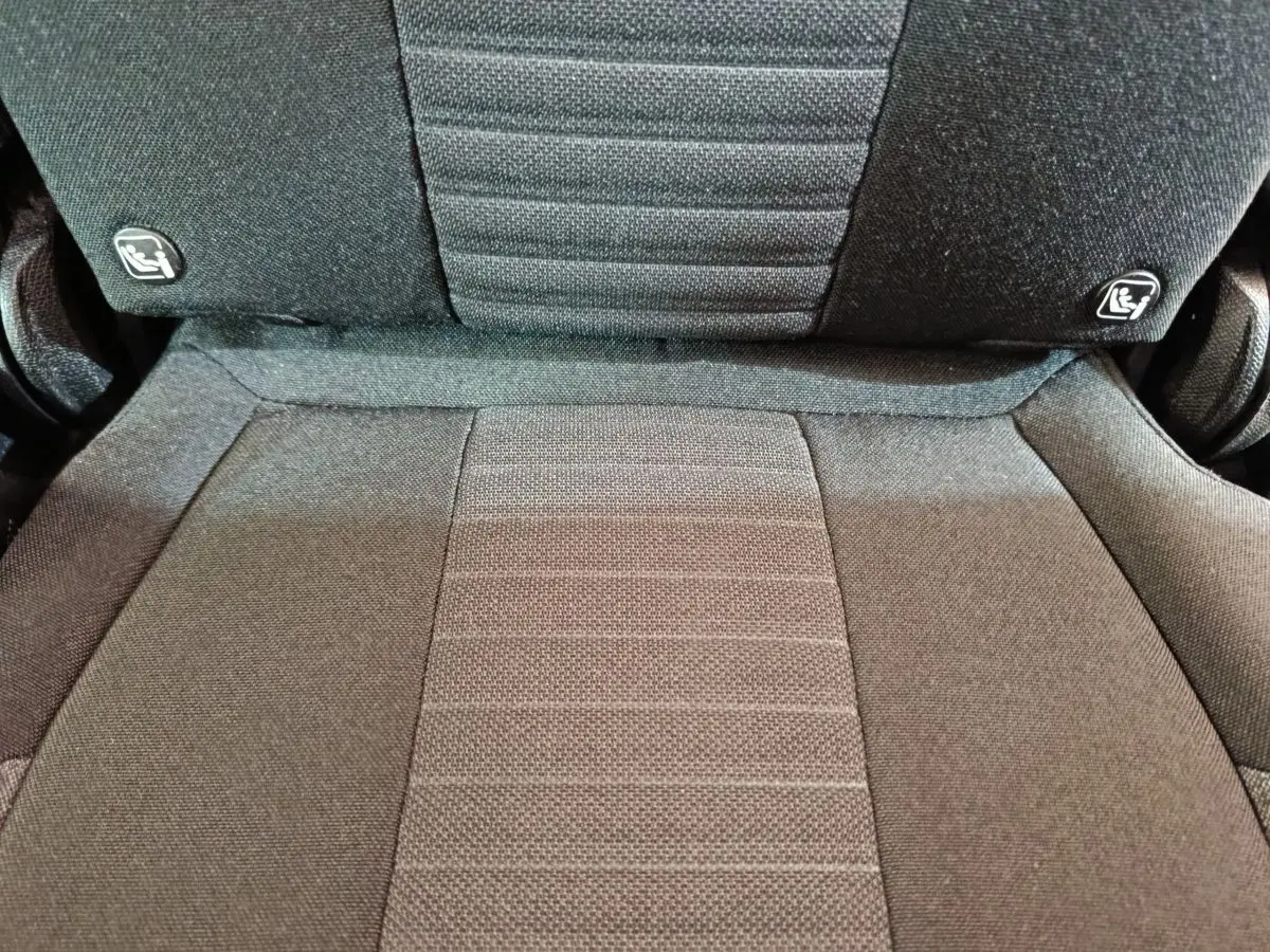 Gros plan sur la partie centrale du siège arrière gris foncé du Peugeot 5008 2023 avec fixation Isofix visible.