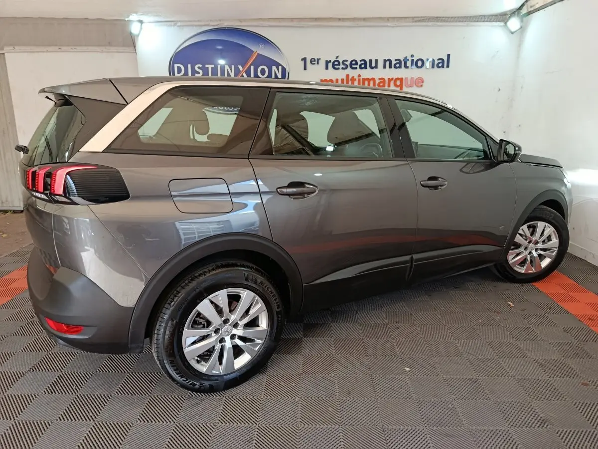 Vue côté droit arrière du Peugeot 5008 gris clair 2023 avec feux arrière à LED et jantes alliage.