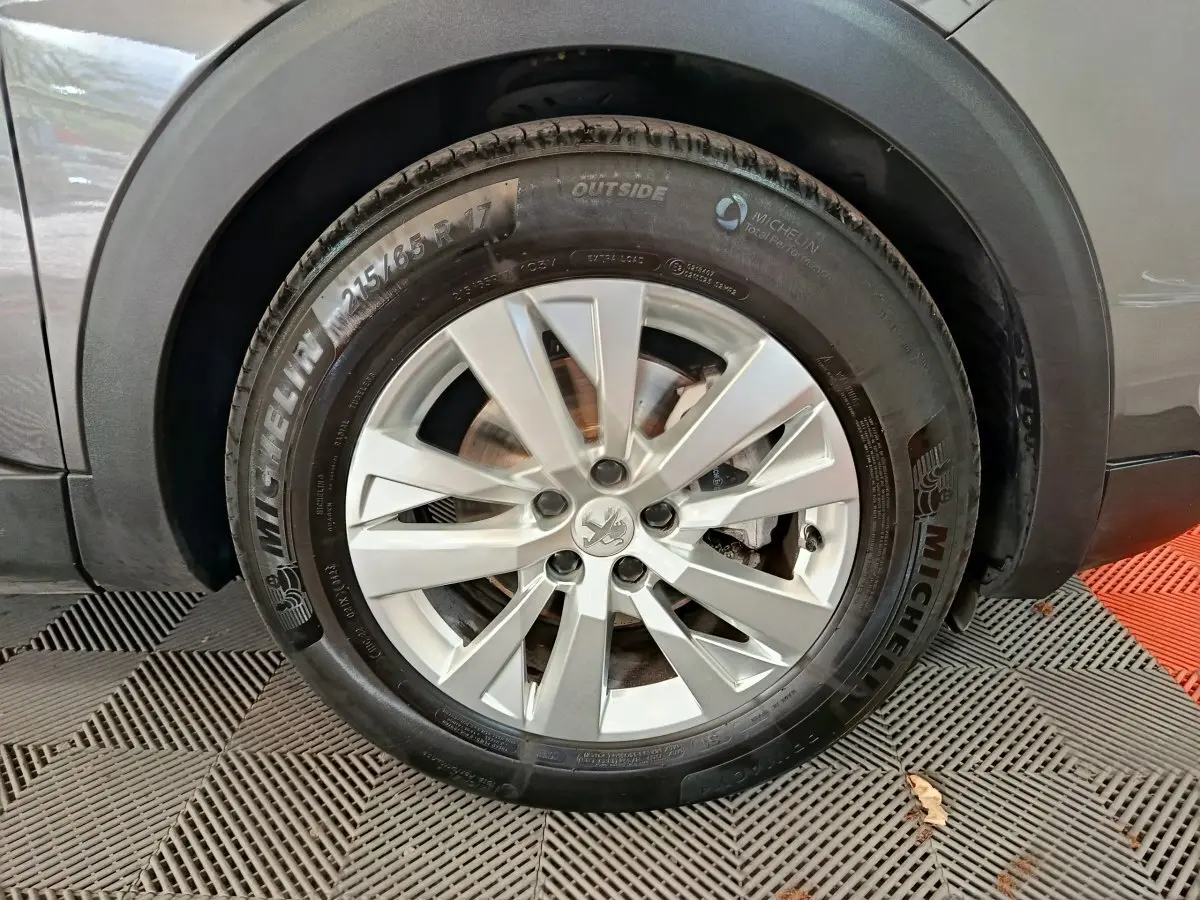 Gros plan sur la roue avant droite gris clair du Peugeot 5008 avec jante alliage et pneu Michelin.