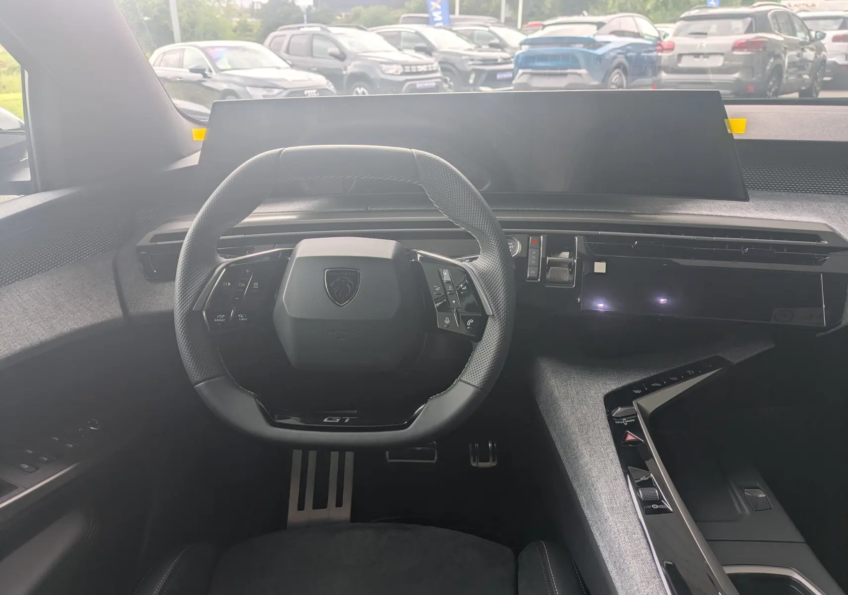 Gros plan sur les commandes de lève-vitres et rétroviseurs côté conducteur du Peugeot 3008 Hybrid bleu Ingaro.