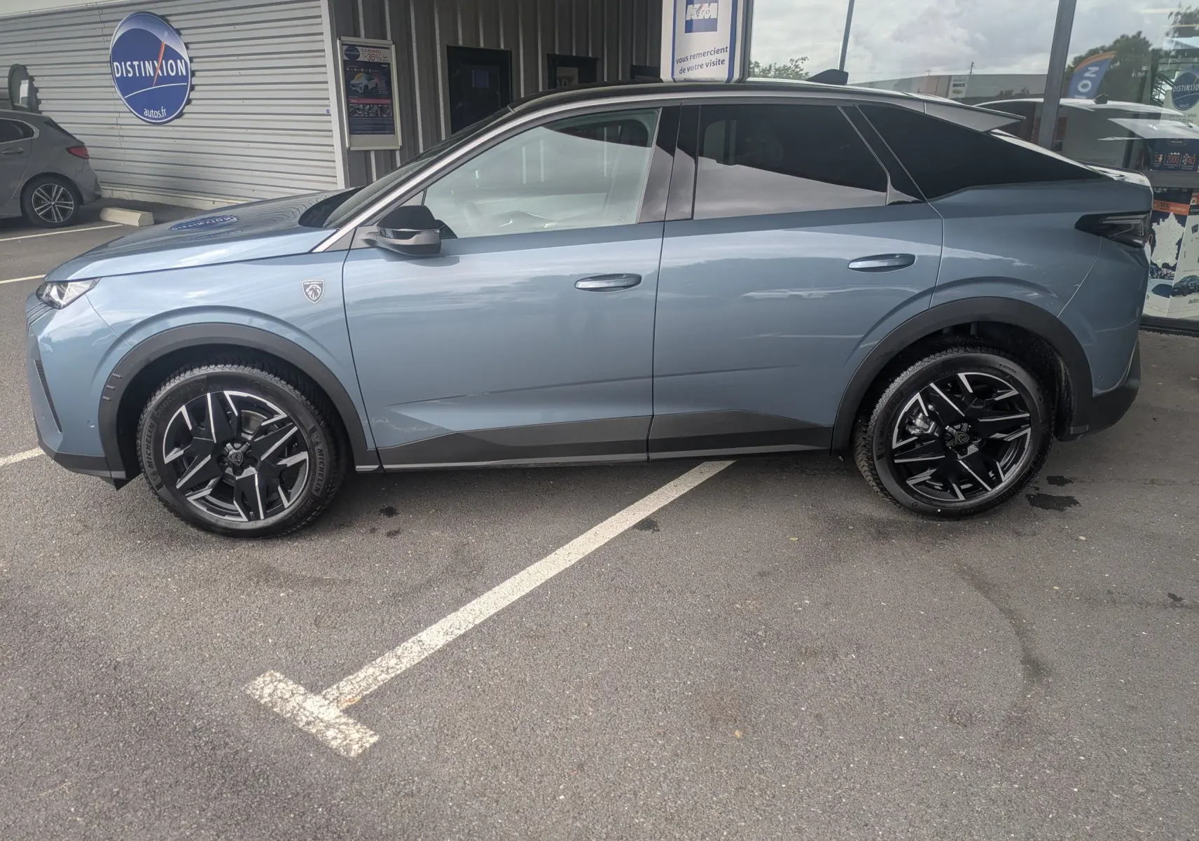 Vue 3/4 arrière droite du Peugeot 3008 Hybrid 145 bleu Ingaro avec toit noir et jantes alliage 19 pouces.
