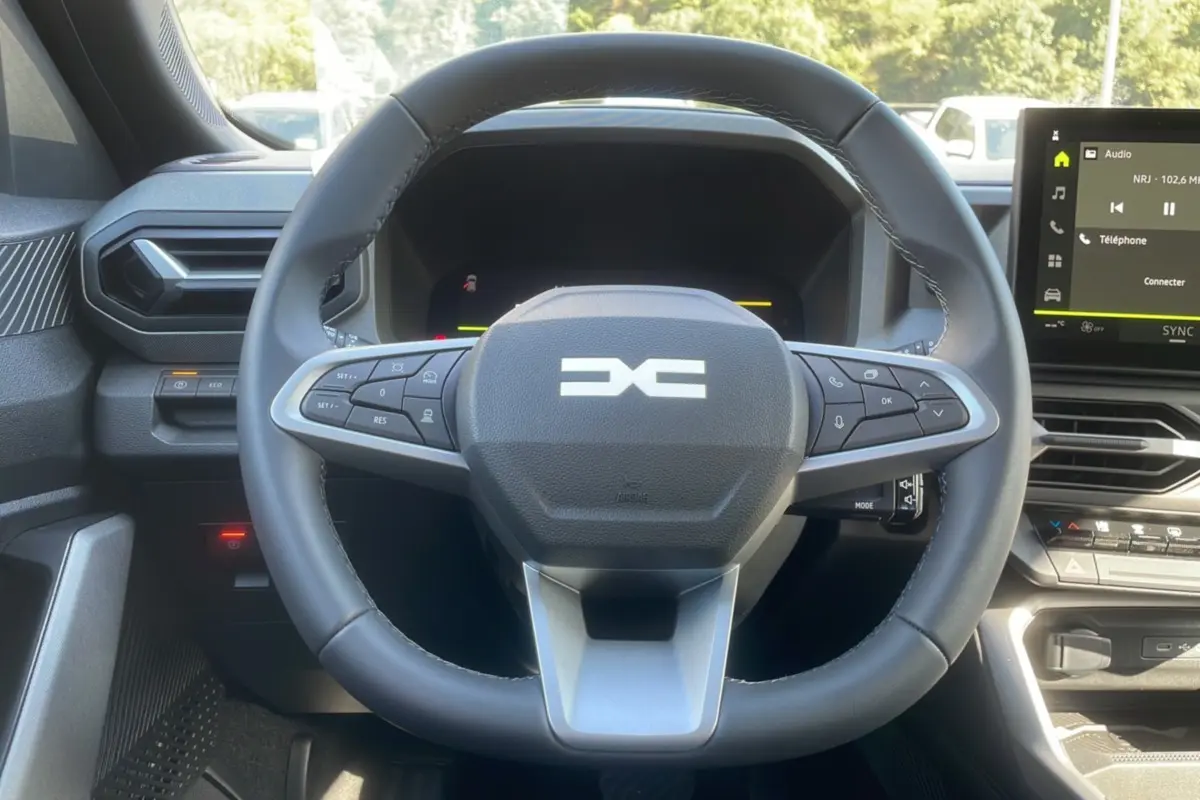 Vue rapprochée du volant cuir noir et du tableau de bord digital du Dacia Bigster Hybrid 155 Journey City.