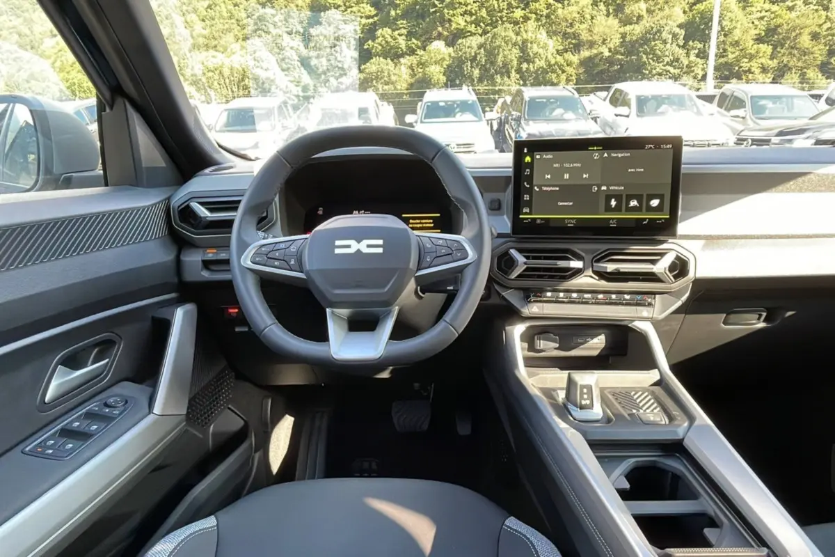 Vue intérieure frontale du tableau de bord du Dacia Bigster Hybrid 155, avec volant cuir et écran tactile 10,1 pouces.