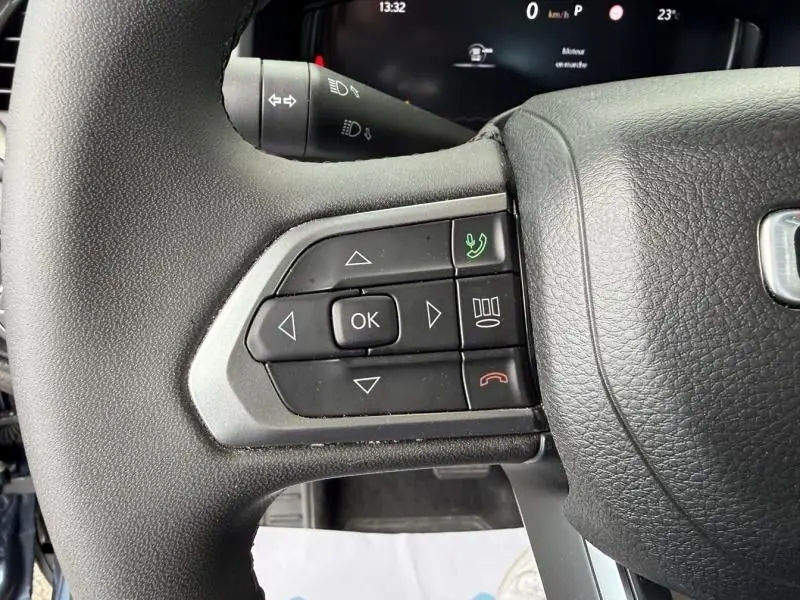 Gros plan sur les commandes au volant du Jeep Renegade 2024, boutons noirs avec fonction appel et navigation.