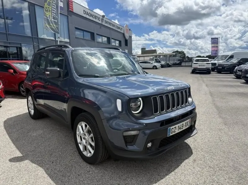 Jeep Renegade bleu métal en vue 3/4 avant droit, avec calandre à sept fentes et phares ronds LED visibles.