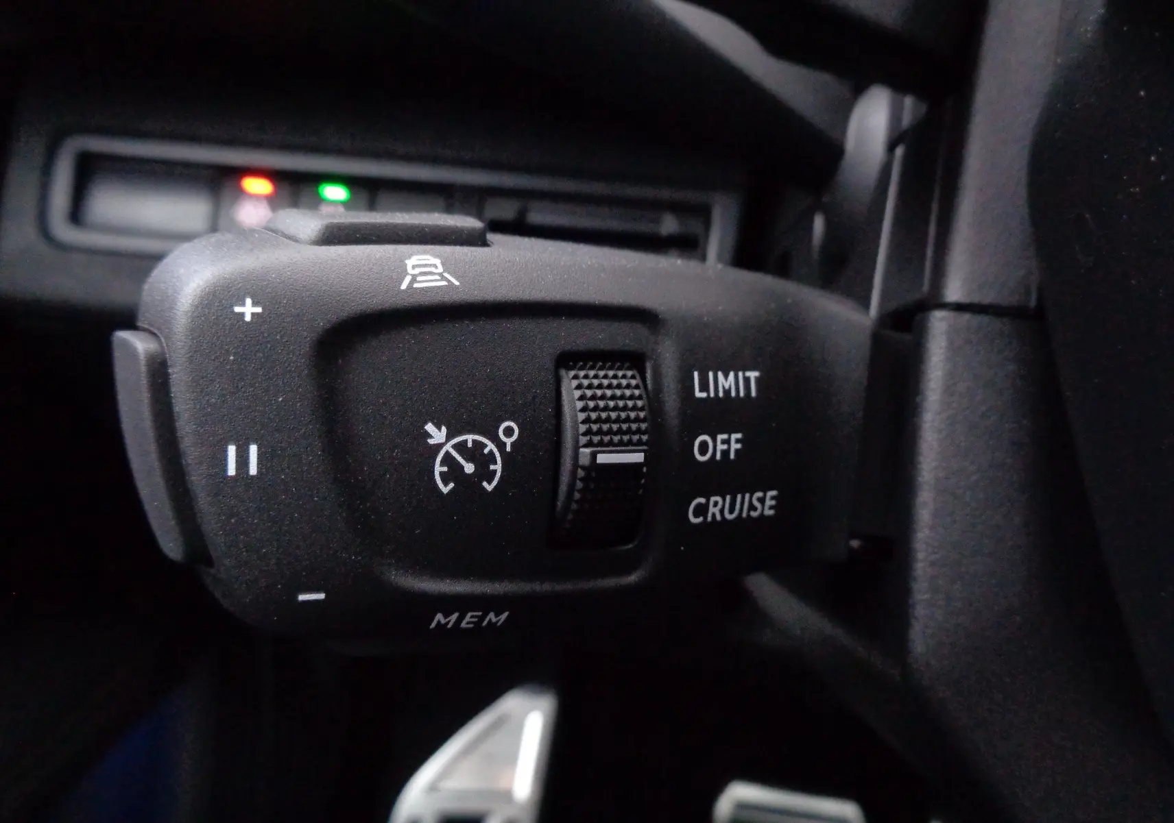 Gros plan sur la commande de régulateur de vitesse du Peugeot 3008 gris Artense, avec molette et symboles blancs visibles.