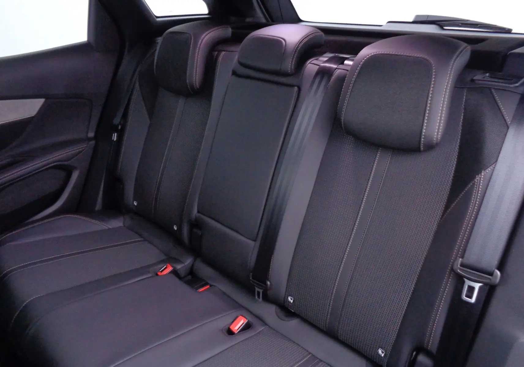 Vue intérieure des sièges arrière noirs avec surpiqûres contrastantes du Peugeot 3008 2023 gris Artense Metal.