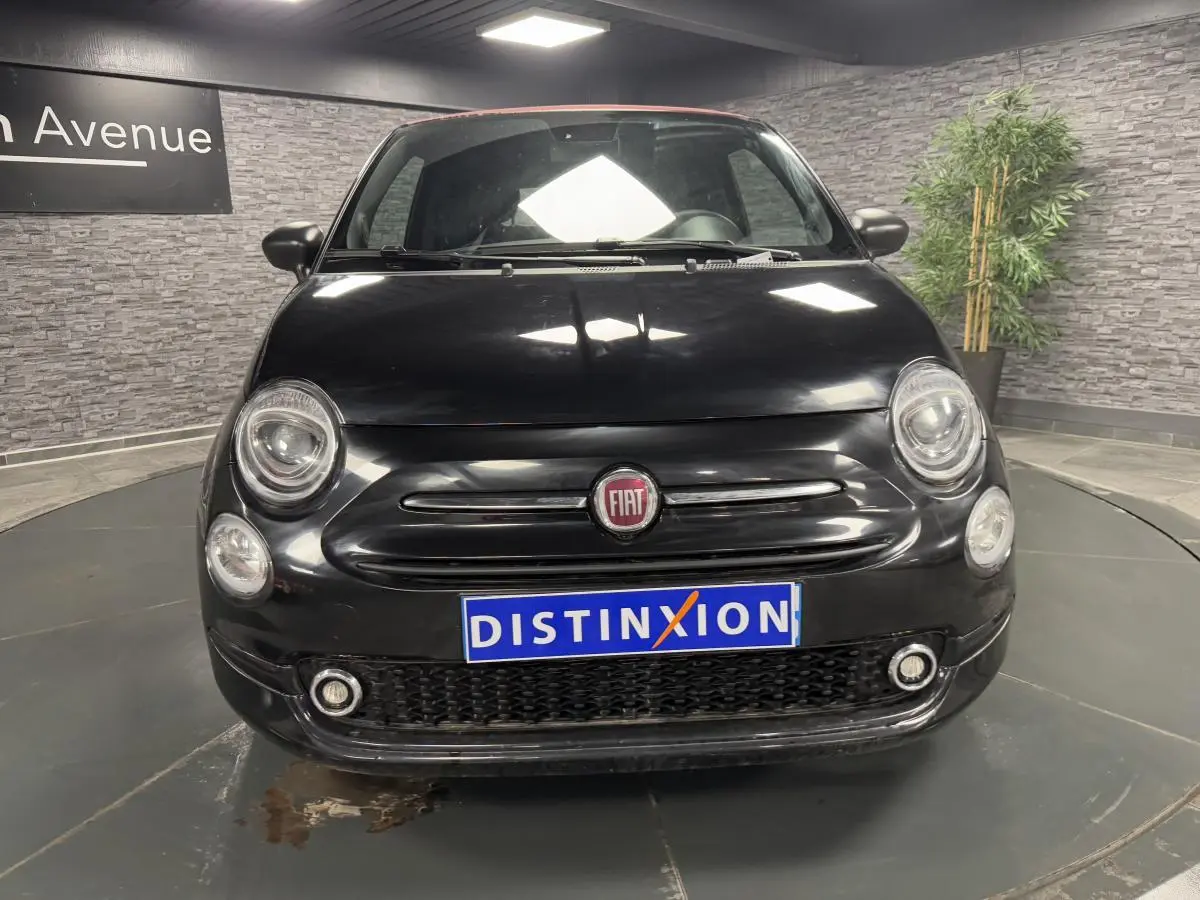 Vue frontale d'une Fiat 500 Cabriolet noire avec capote rouge et logo FIAT visible sur la calandre.