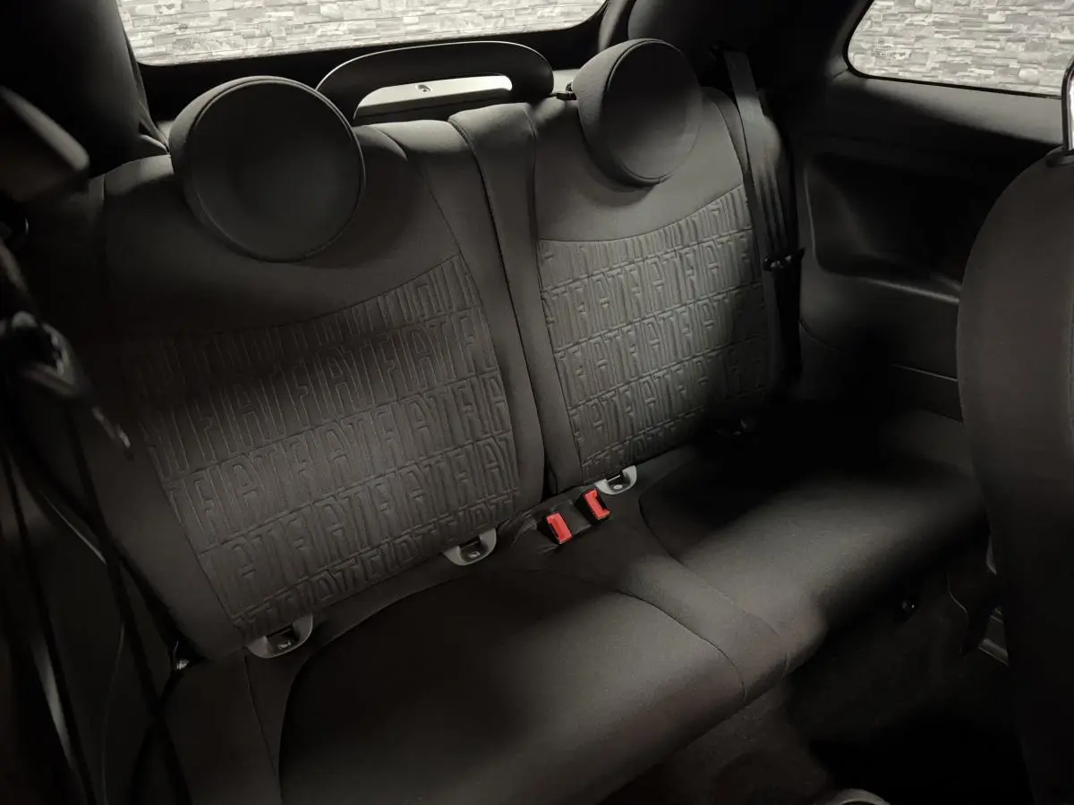 Banquette arrière noire de la Fiat 500 Cabriolet 2024, avec monogramme FIAT en relief sur les dossiers.