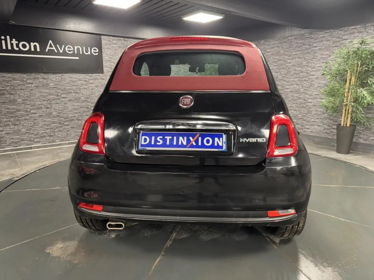 Vue arrière d'une Fiat 500 Cabriolet noire avec capote rouge et logo Hybrid visible sur le coffre.
